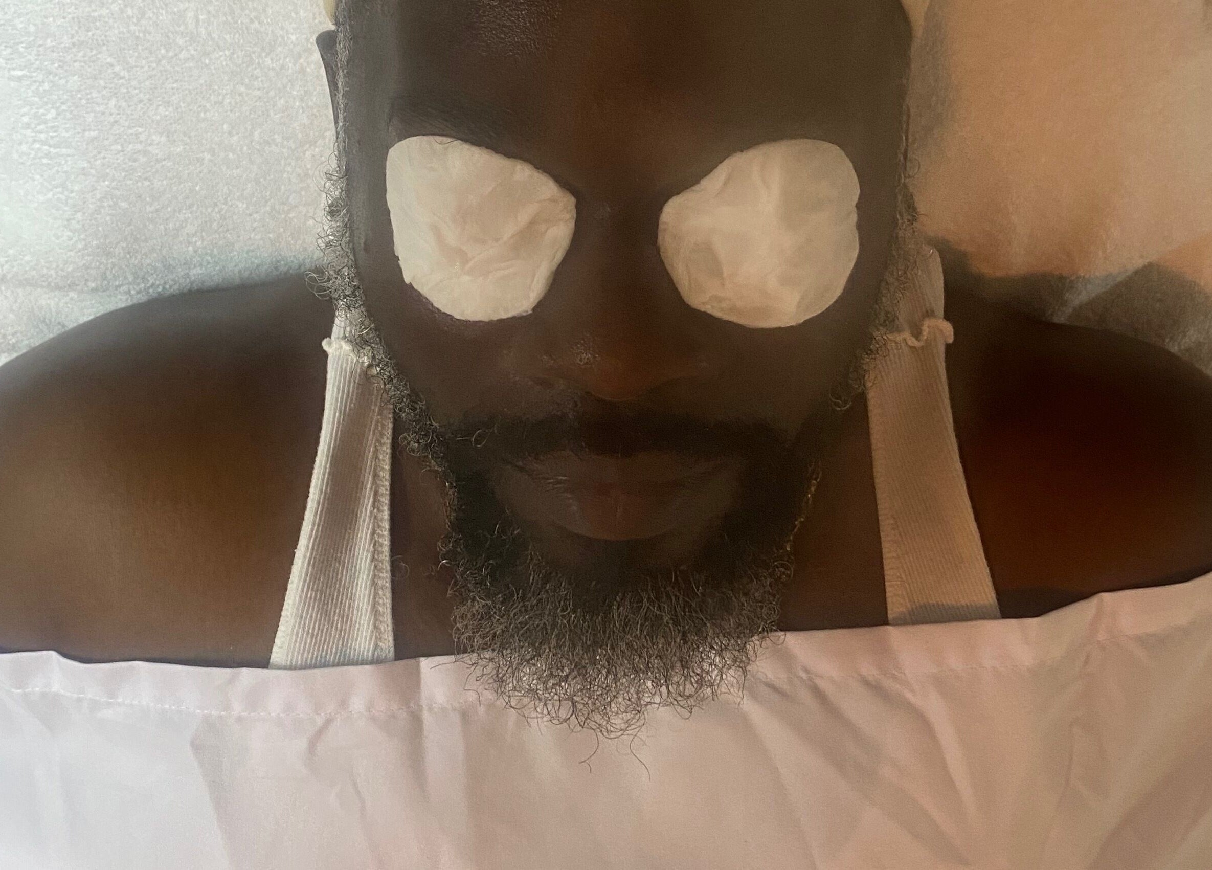 Man enjoying facial treatment at SkinDeep in Nassau, New Providence, BS for ultimate relaxation.