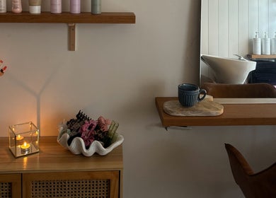 Serene salon corner at Sandy Salon, Sandy Beach, New South Wales, AU with flowers, cup, and hair accessories.