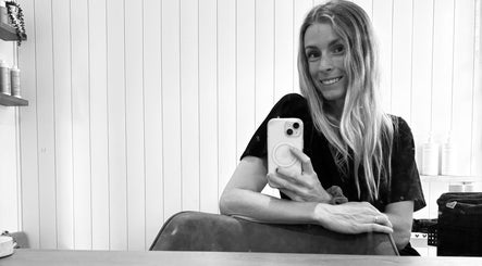 Smiling woman takes a mirror selfie at Sandy Salon, Sandy Beach, New South Wales, AU.