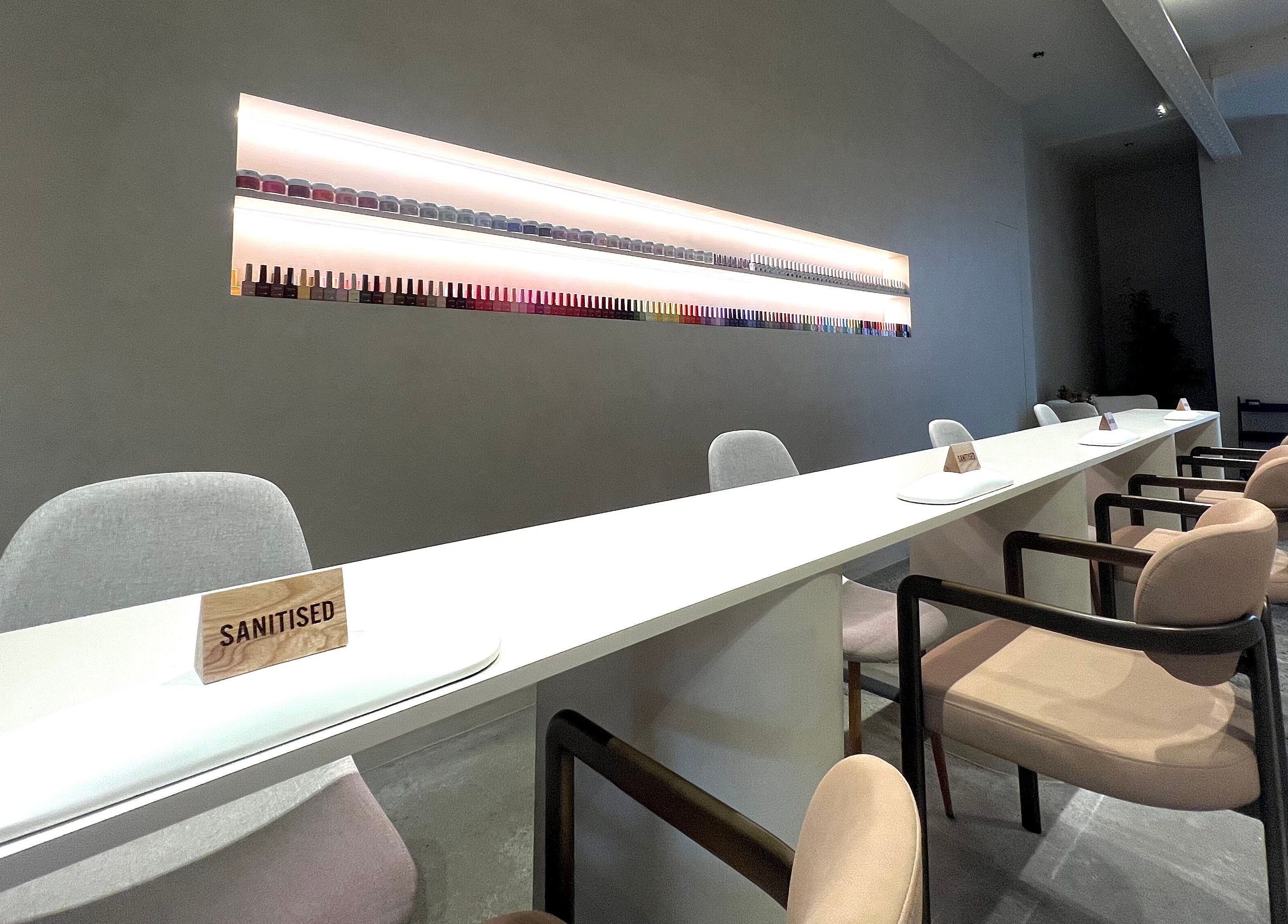 Modern nail salon at NAILTIME, Auckland, NZ with a sleek, clean design and neatly arranged nail polish display.
