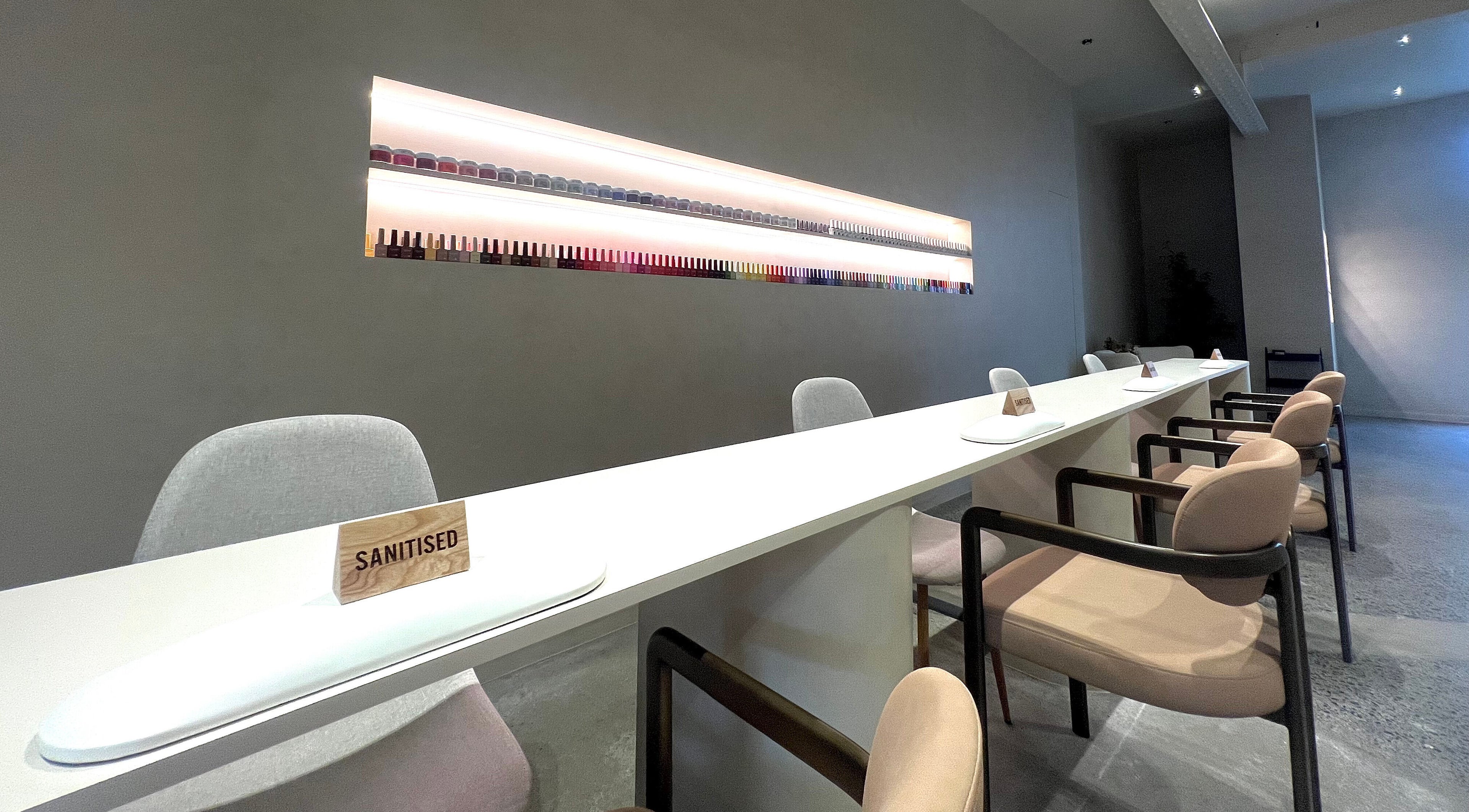 Modern nail salon at NAILTIME, Auckland, NZ with a sleek, clean design and neatly arranged nail polish display.