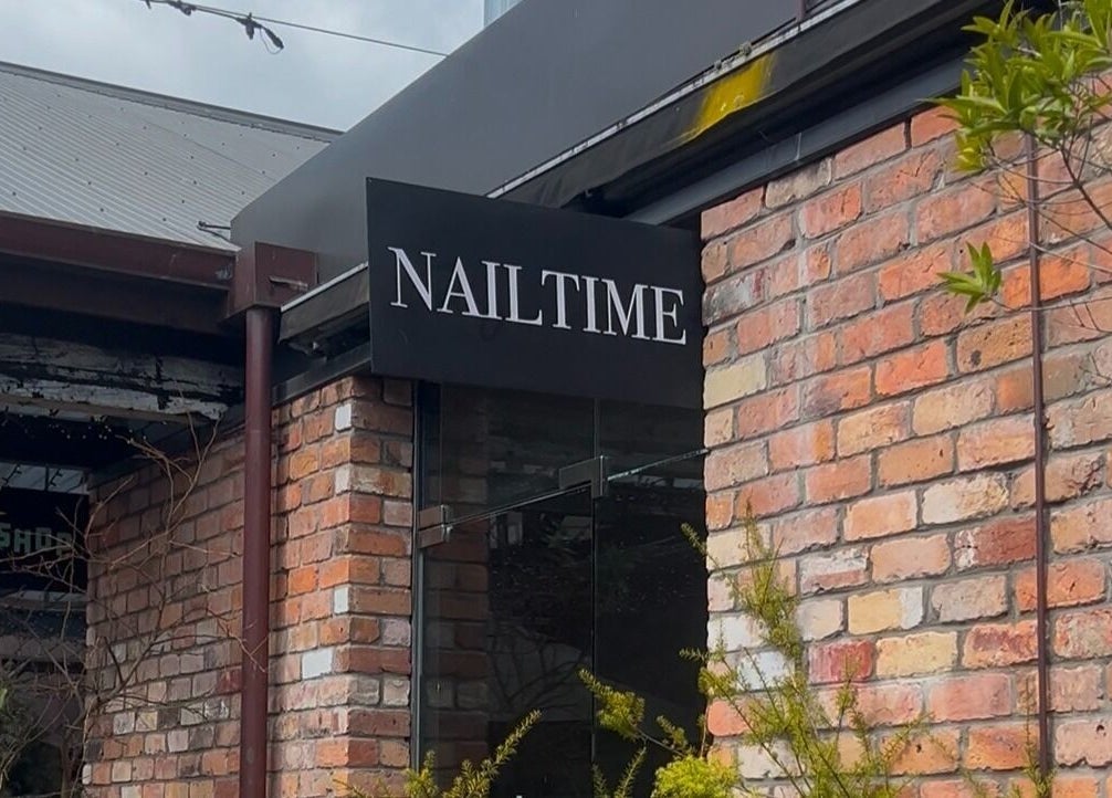 Front view of NAILTIME in Auckland, Auckland, NZ with brick wall and stylish signage.