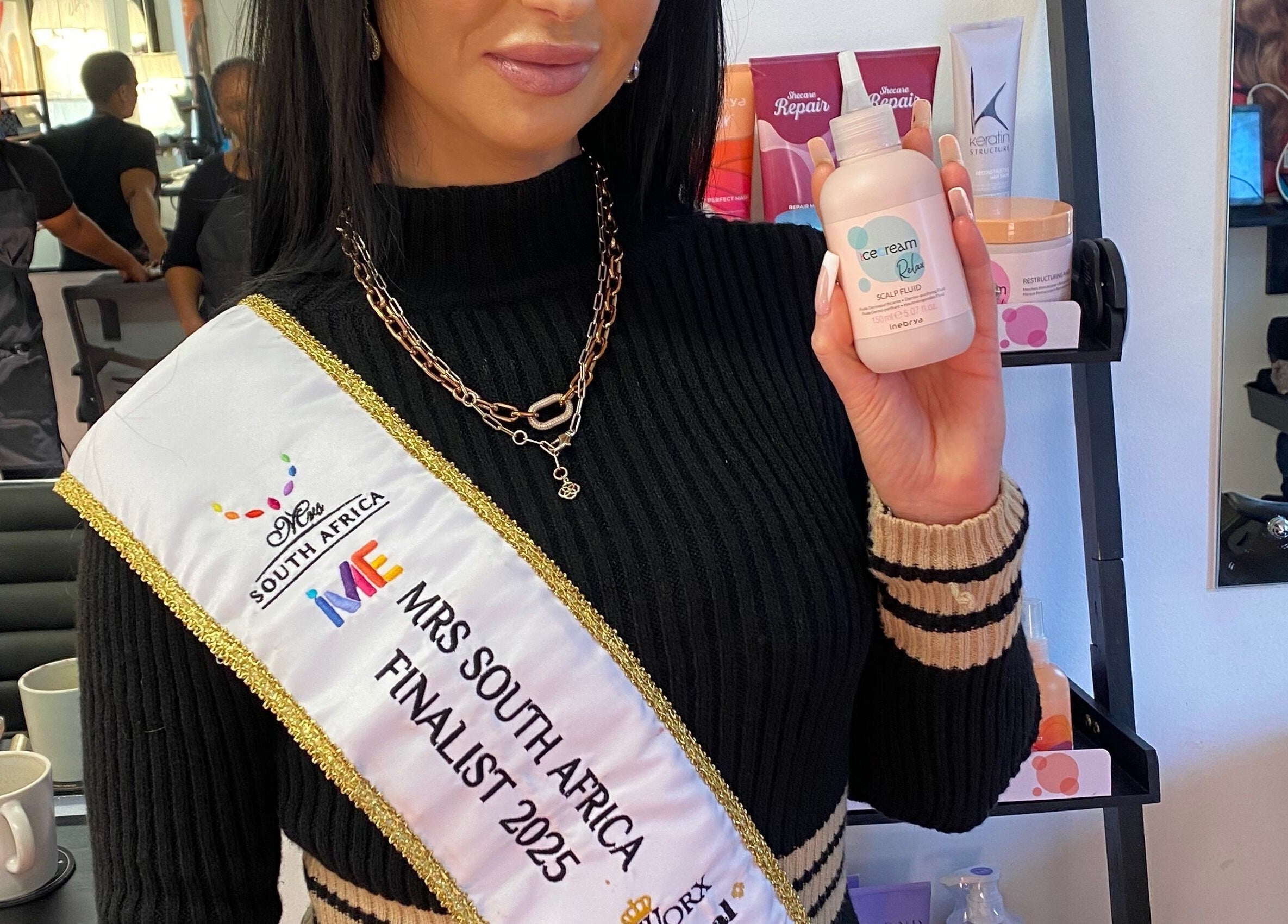 Client holding hair product at Hair Trendz by Crystal in Ballito, Kwazulu-natal, ZA. Modern salon interior.