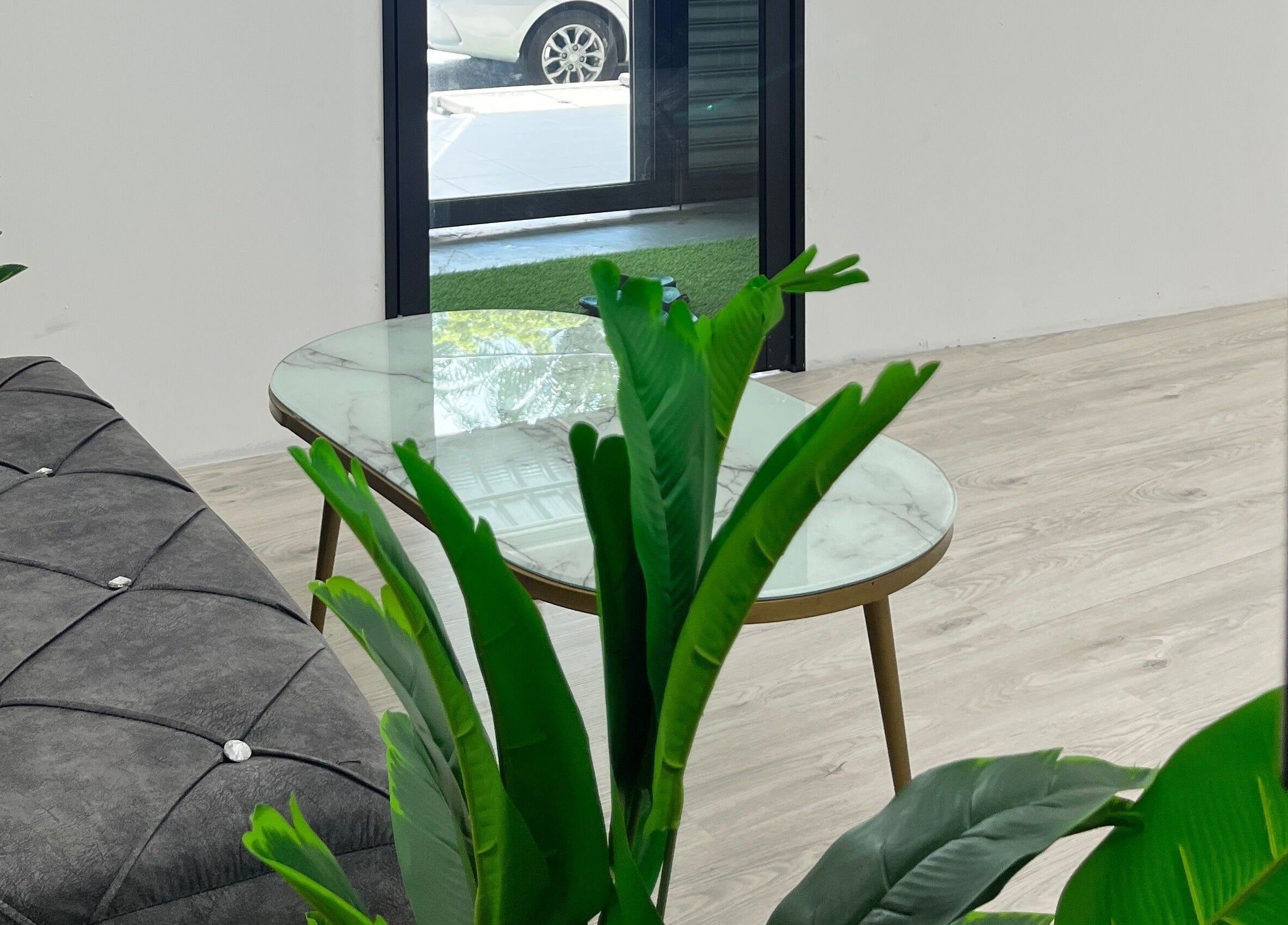 Chic waiting area at Beauty Bound, Sitiawan, Perak, MY with a comfy sofa and lush plants.