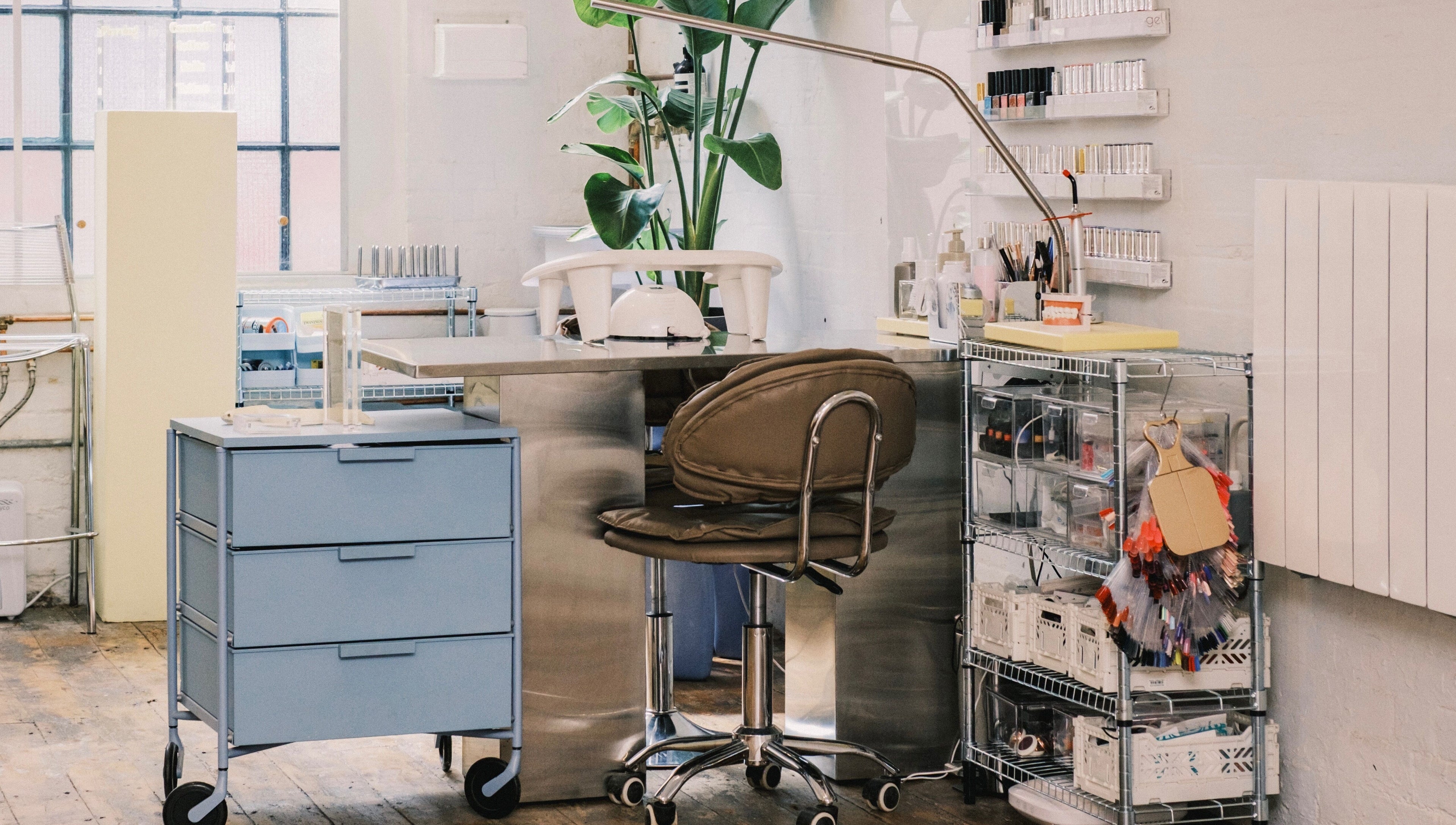 Modern nail salon workstation at Milk Digits, London, England with stylish decor and organized supplies.