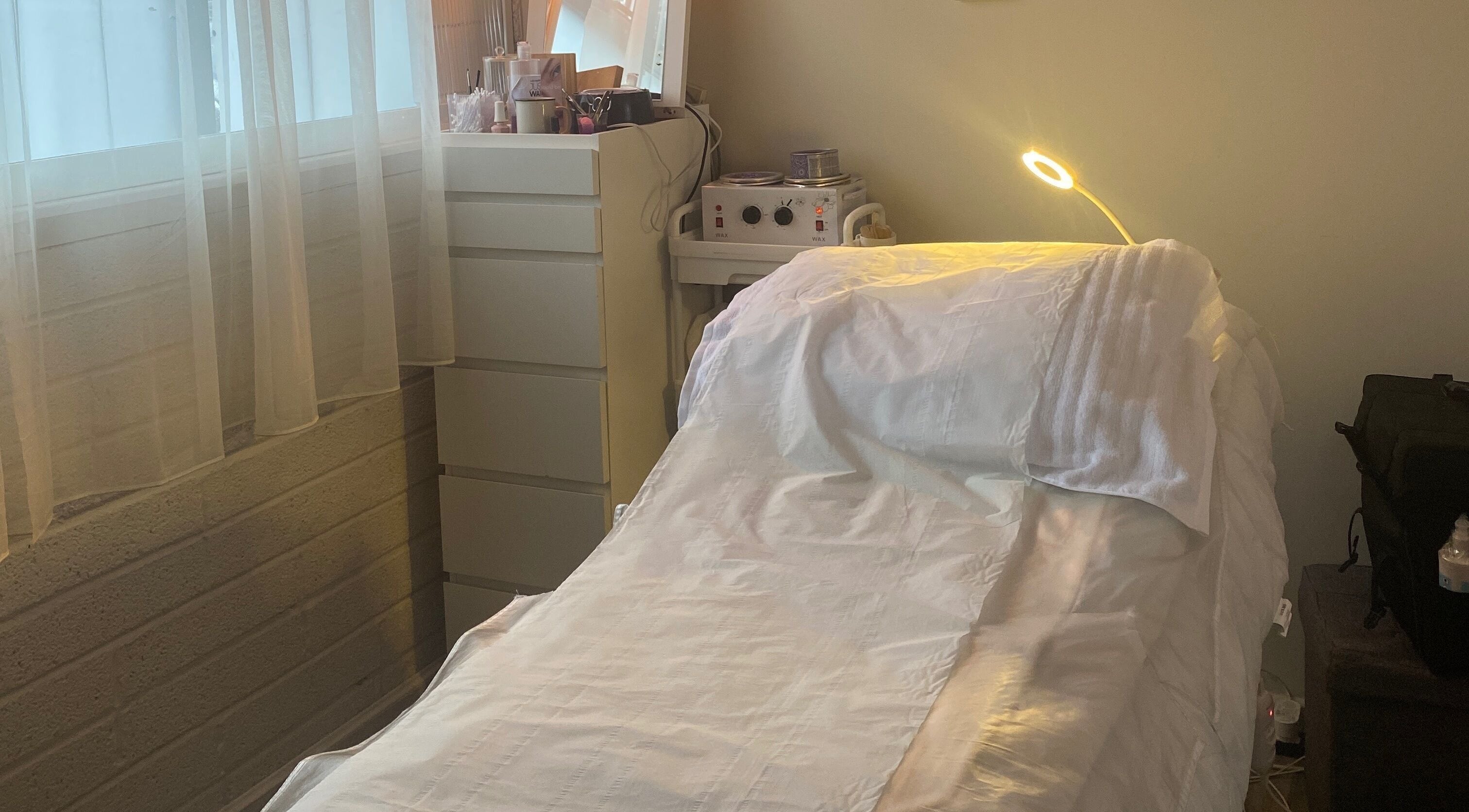 Relaxing treatment room at JKA Beauty Clinic Equinox Center in Bray, County Dublin, IE, with neatly arranged bed.