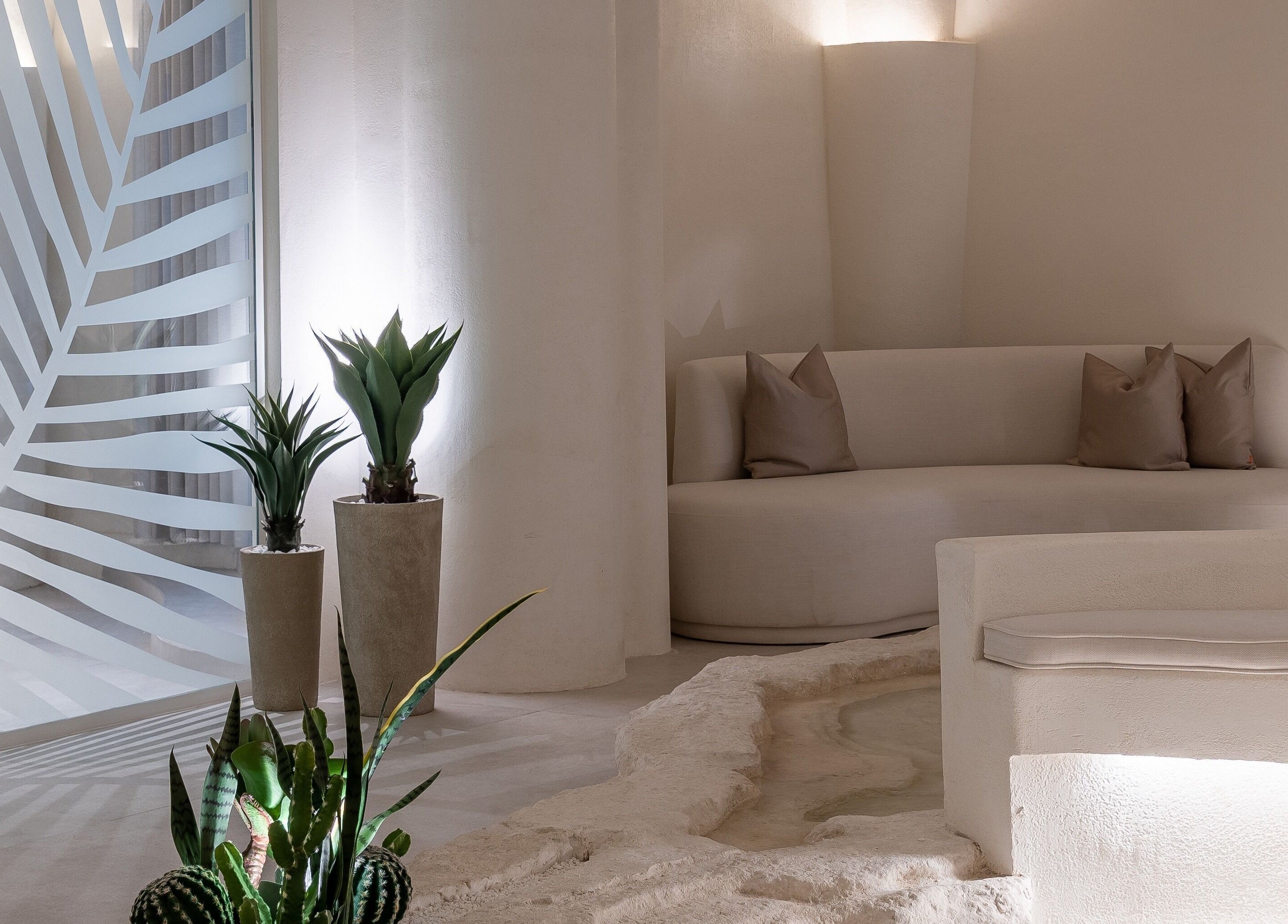 Elegant lounge area at Treat Men's Luxury Spa, Riyadh, showcasing modern design with plants and cozy seating.