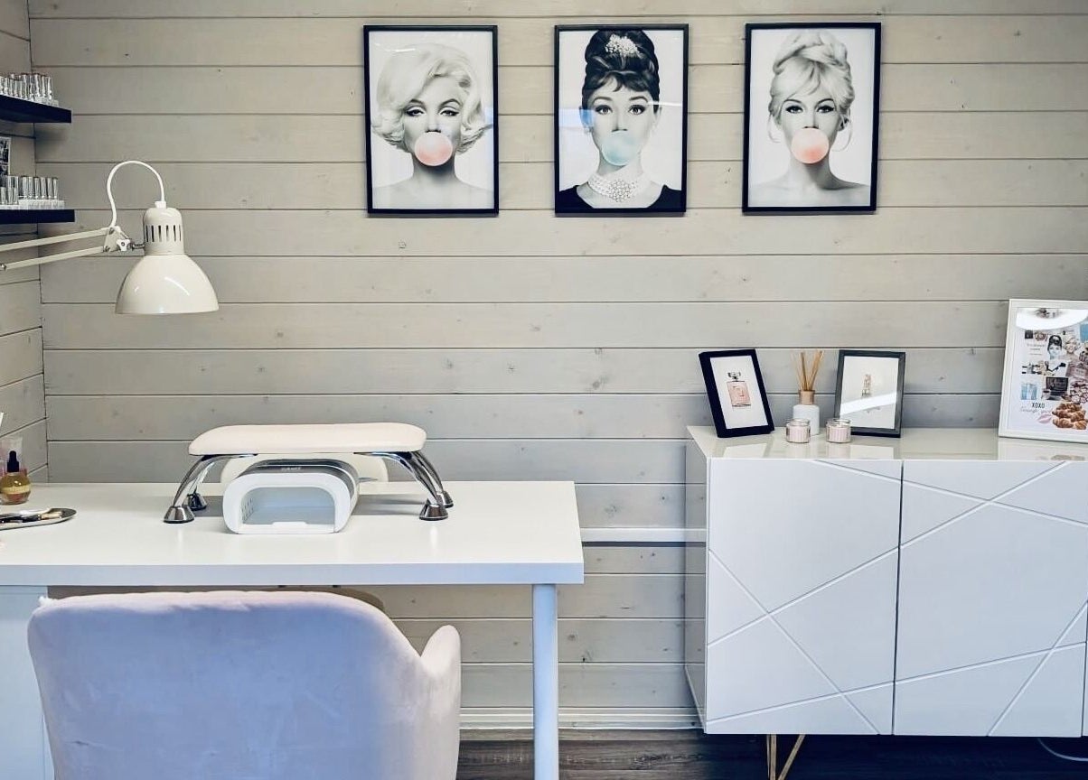 Chic nail salon interior at Gossip & Glamour, Chippenham, England, GB, with stylish decor and pop art portraits.