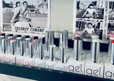 Sleek gel nail polish bottles at Gossip & Glamour, Chippenham, England, GB beside vintage movie posters.