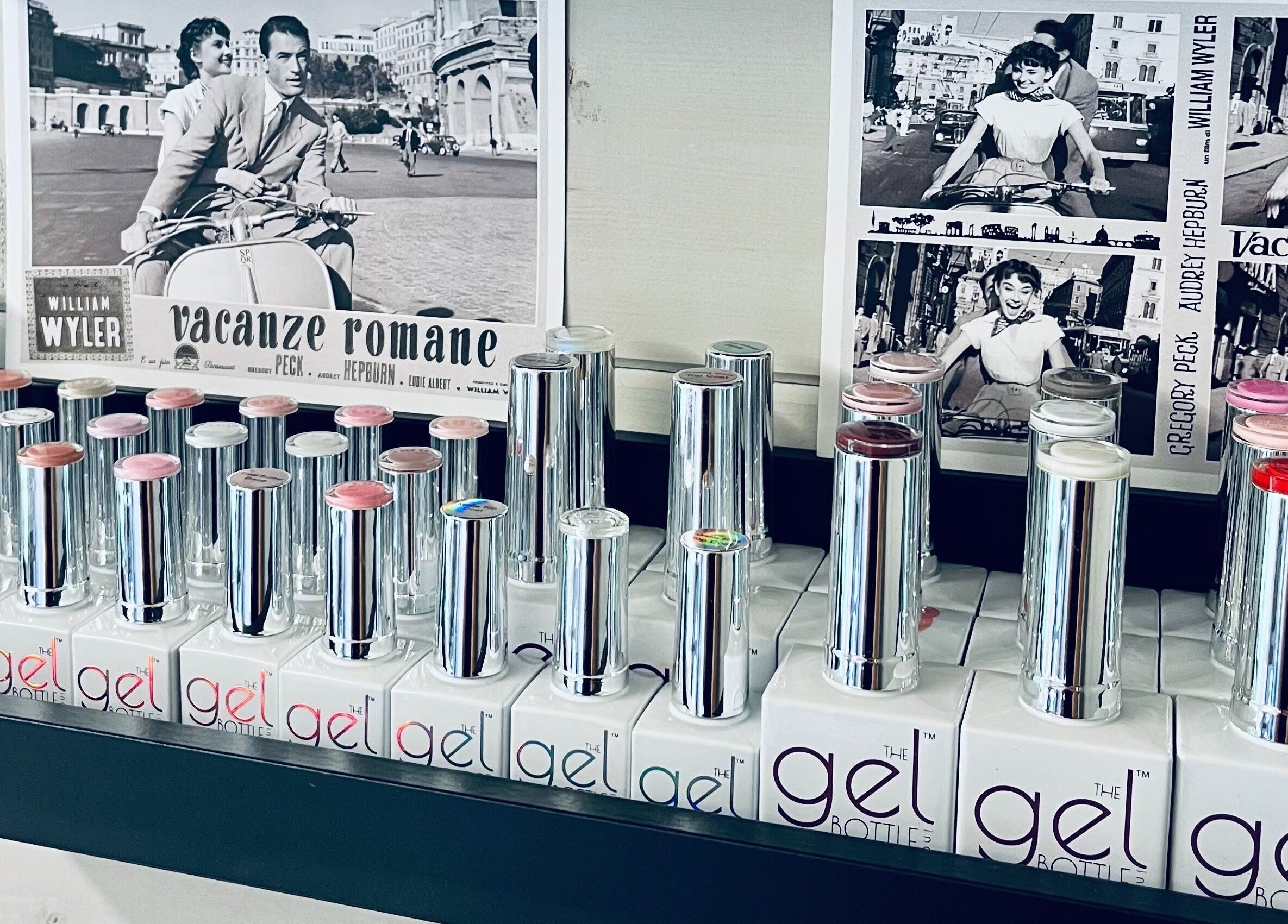 Sleek gel nail polish bottles at Gossip & Glamour, Chippenham, England, GB beside vintage movie posters.
