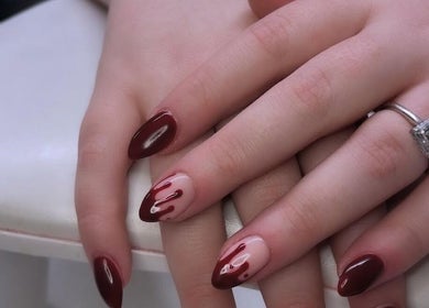 Stunning nail art design at Gossip & Glamour, Chippenham, England, GB showcasing elegant maroon and nude colors.