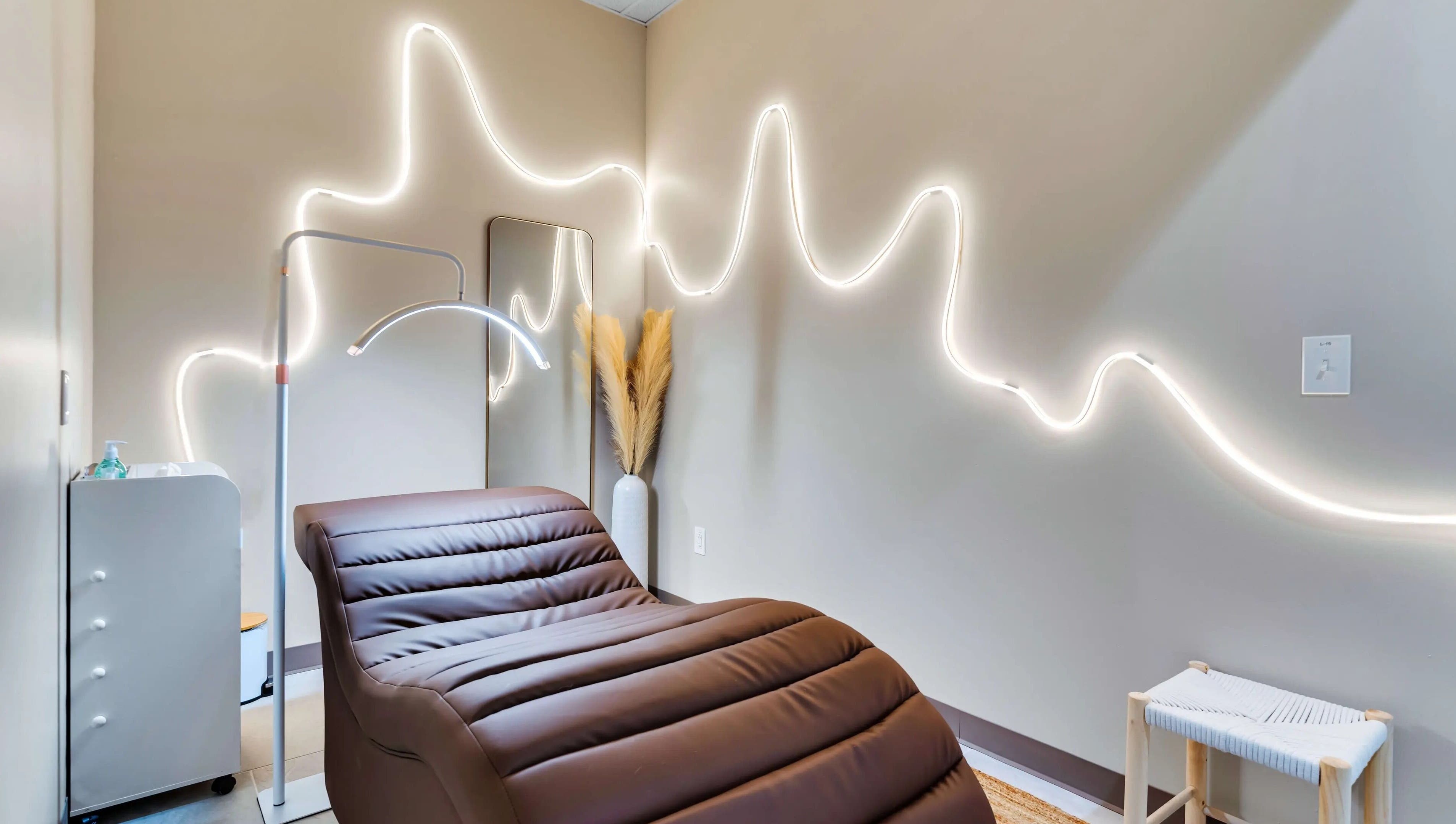 Relaxing treatment room at Korra Beauty Bar in Southlake, Texas, US with ambient lighting and cozy chair.