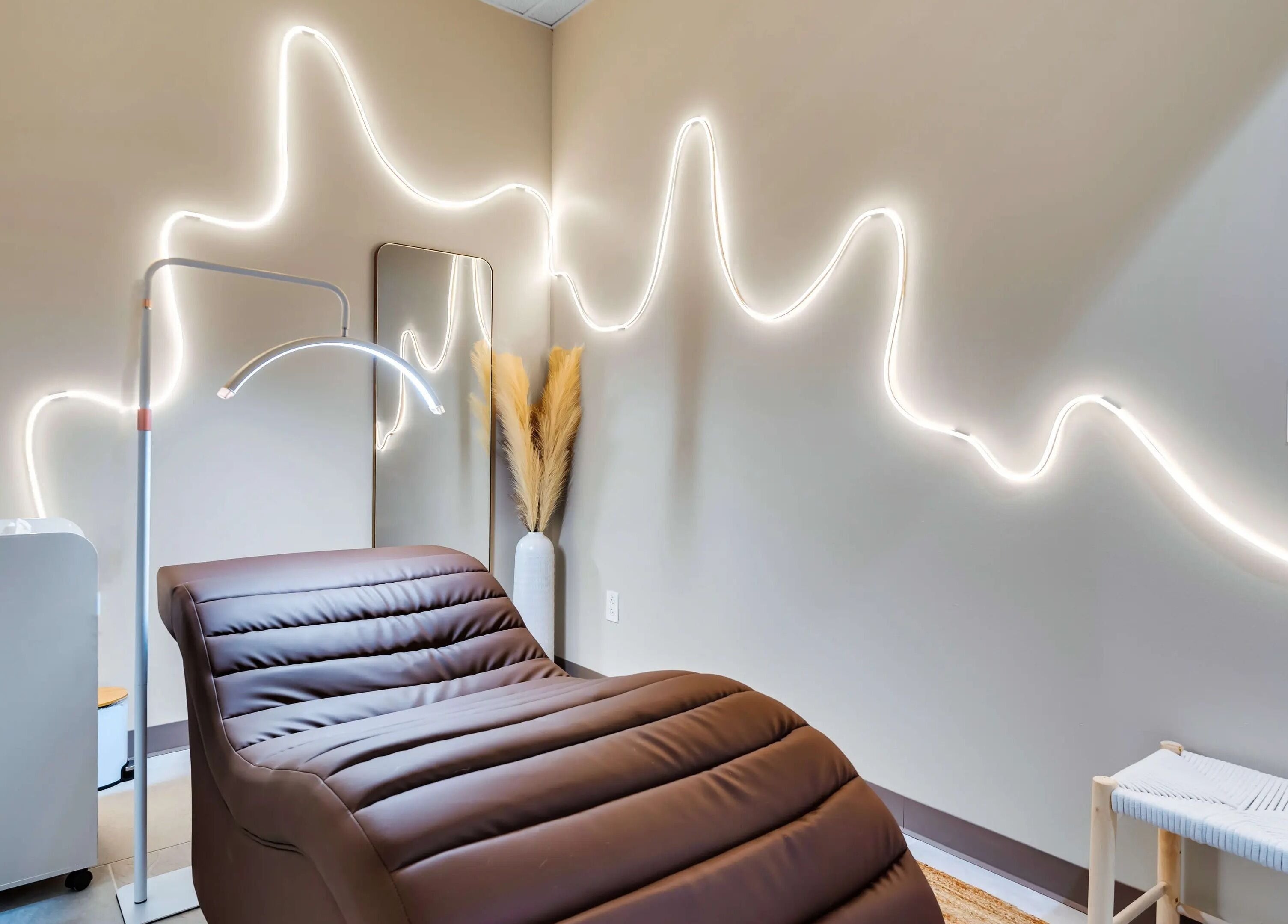 Relaxing treatment room at Korra Beauty Bar in Southlake, Texas, US with ambient lighting and cozy chair.