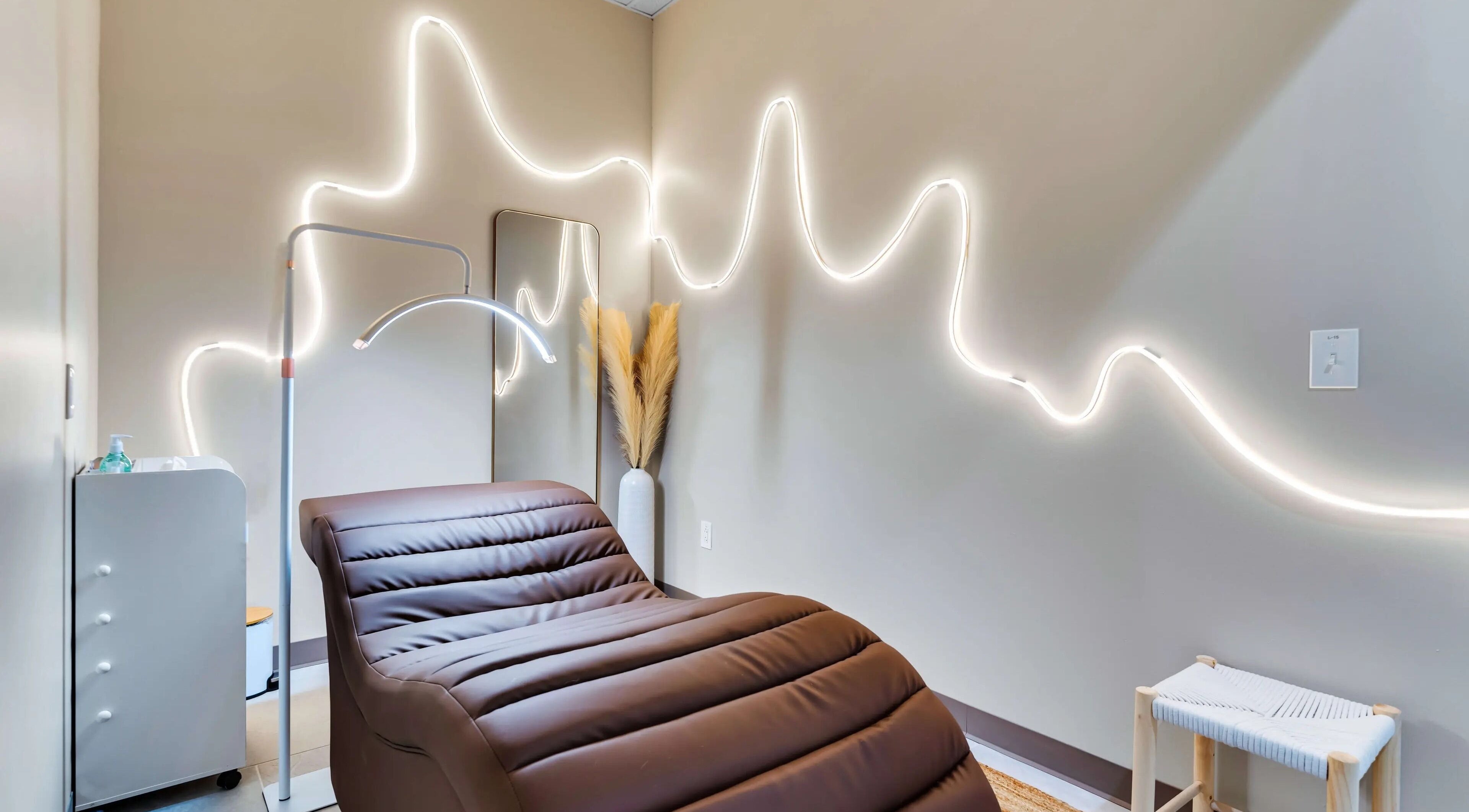 Relaxing treatment room at Korra Beauty Bar in Southlake, Texas, US with ambient lighting and cozy chair.