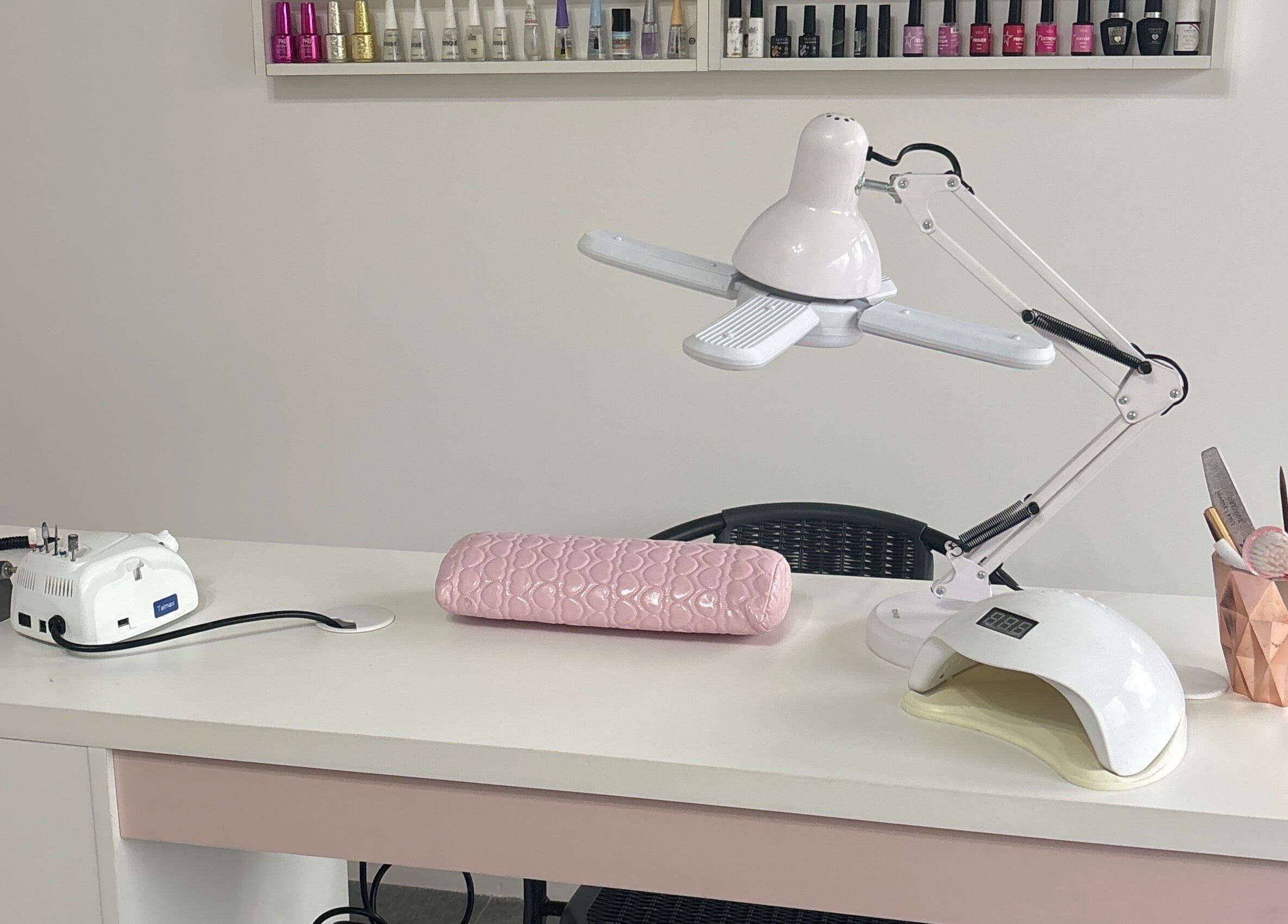 Mesa de manicure no Arrazus Studio de Beleza, Paraná, PR, com ferramentas e lâmpada moderna.