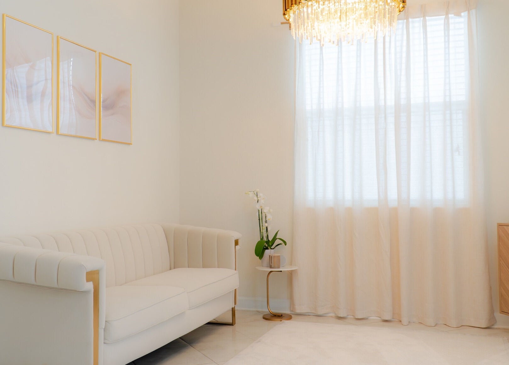 Sala de espera elegante no Studio Amarse em Winter Garden, Florida, US com sofá creme e cortinas brancas.