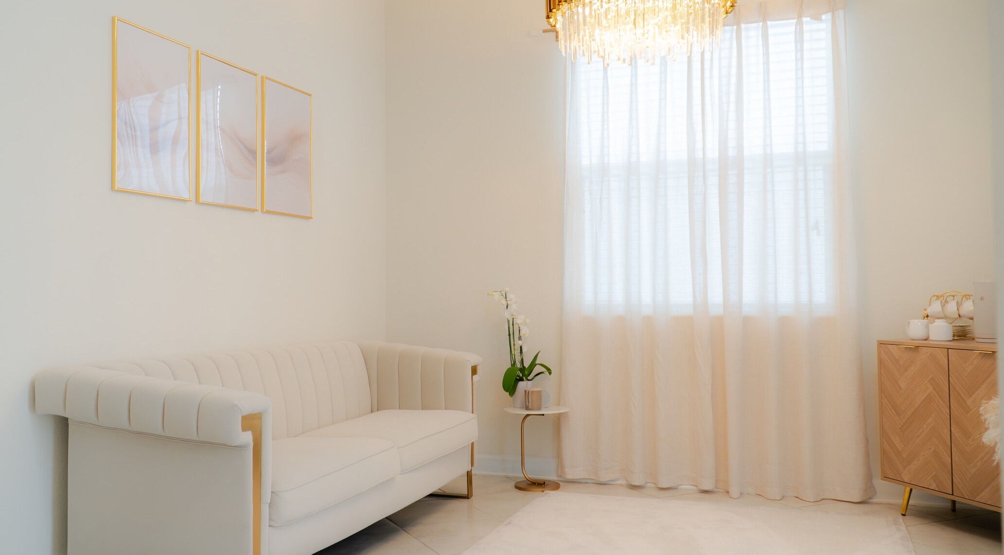 Sala de espera elegante no Studio Amarse em Winter Garden, Florida, US com sofá creme e cortinas brancas.