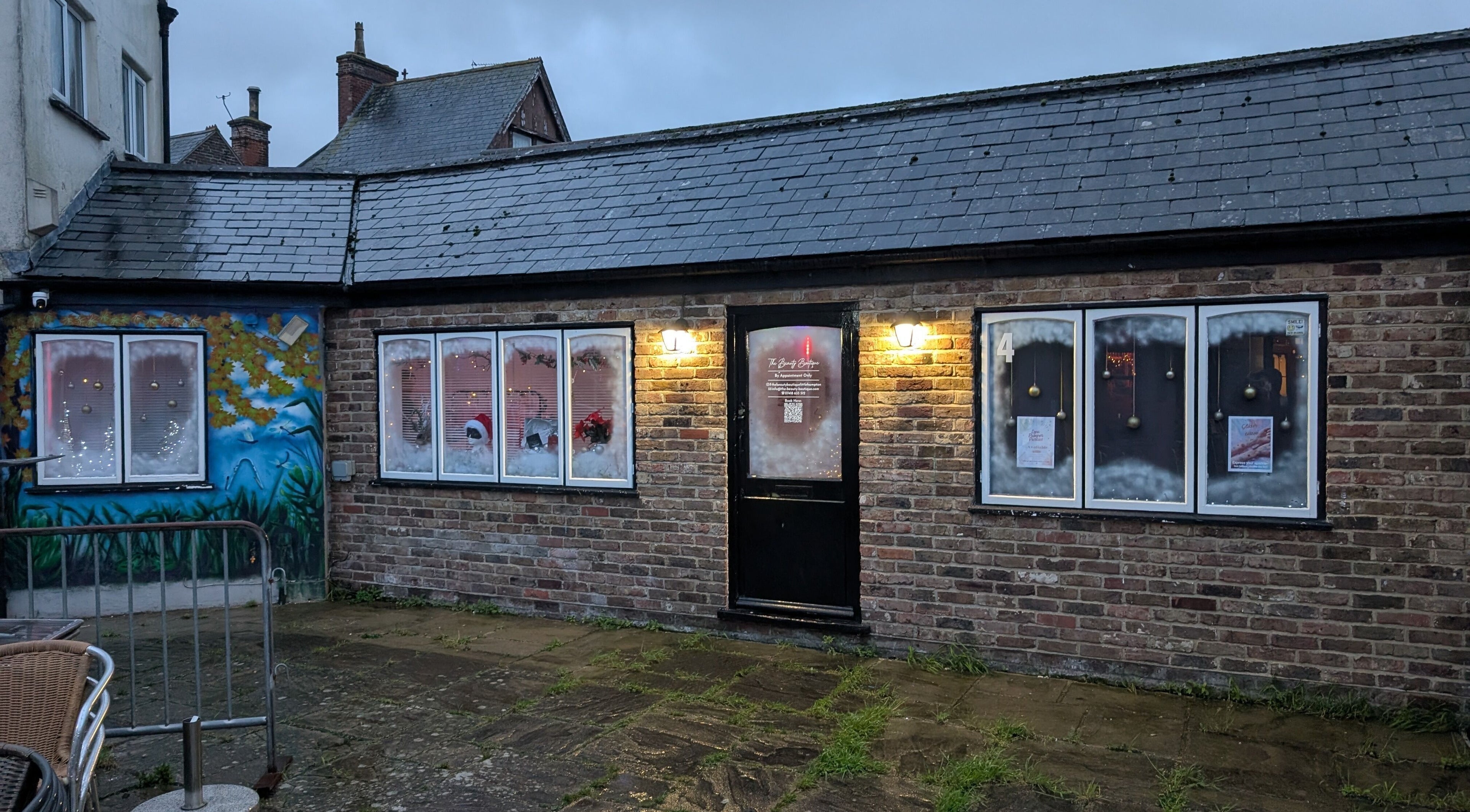 The Beauty Boutique's festive exterior in Littlehampton, England, GB, with holiday decor and warm lighting.