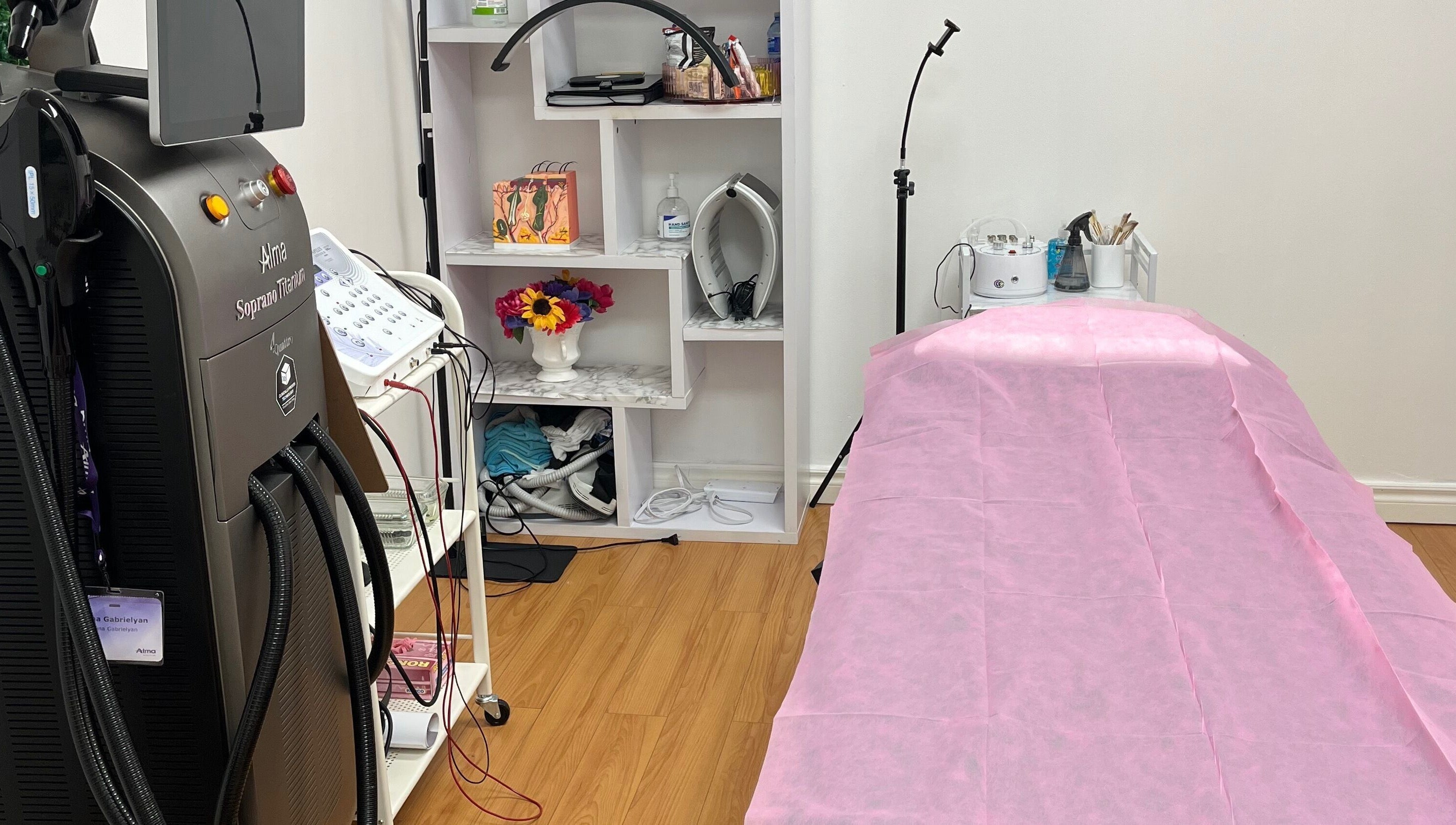 Treatment room at Silky Skin in Toronto, Ontario, CA, featuring advanced equipment and a pink-covered bed.