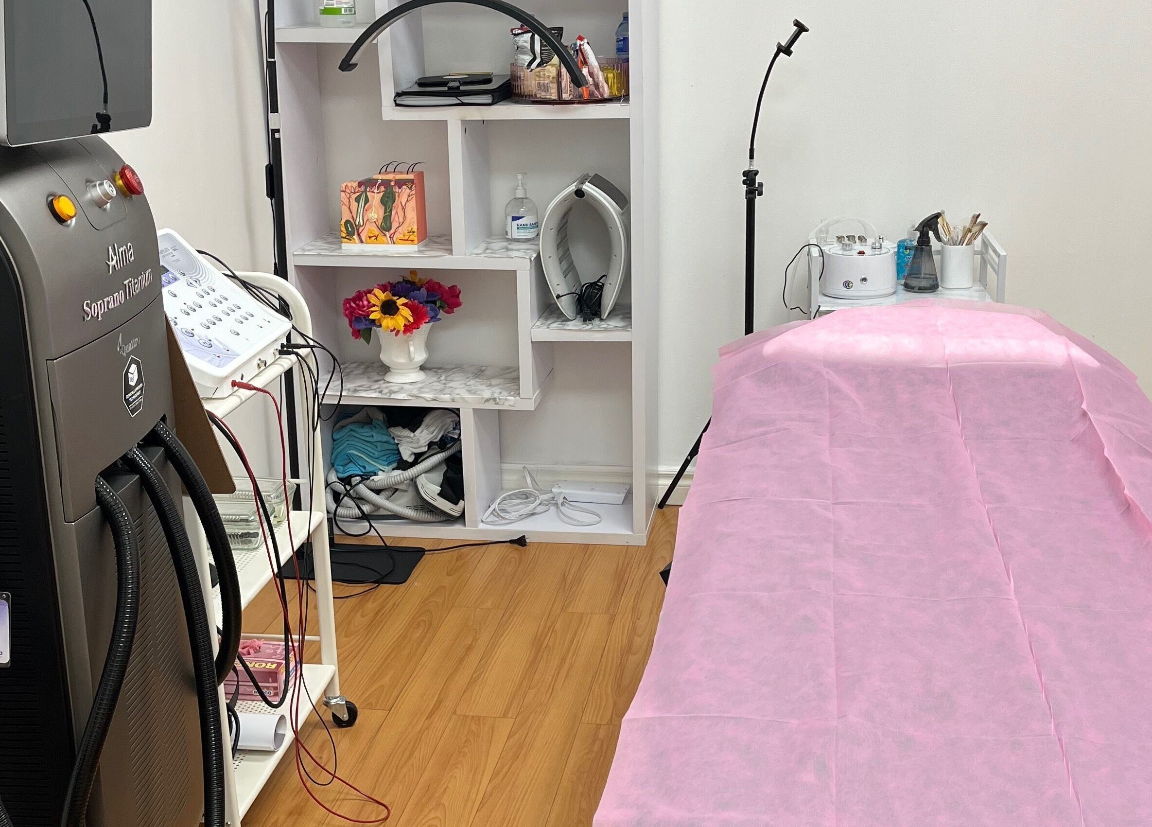 Treatment room at Silky Skin in Toronto, Ontario, CA, featuring advanced equipment and a pink-covered bed.