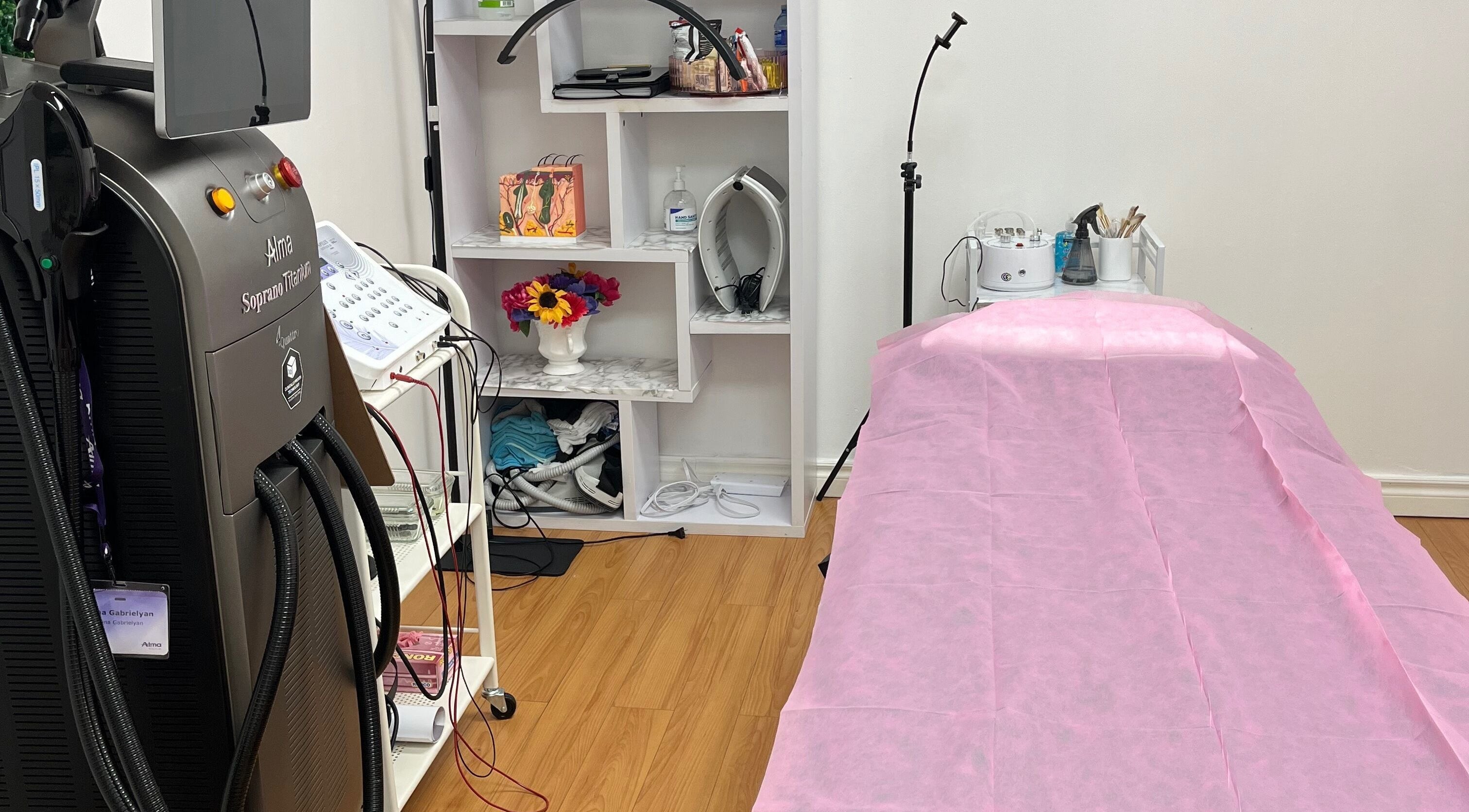 Treatment room at Silky Skin in Toronto, Ontario, CA, featuring advanced equipment and a pink-covered bed.
