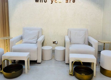 Relaxing pedicure station at Goldn Muse Beauty Salon, Dubai, Dubai, AE with plush seating and gold accents.