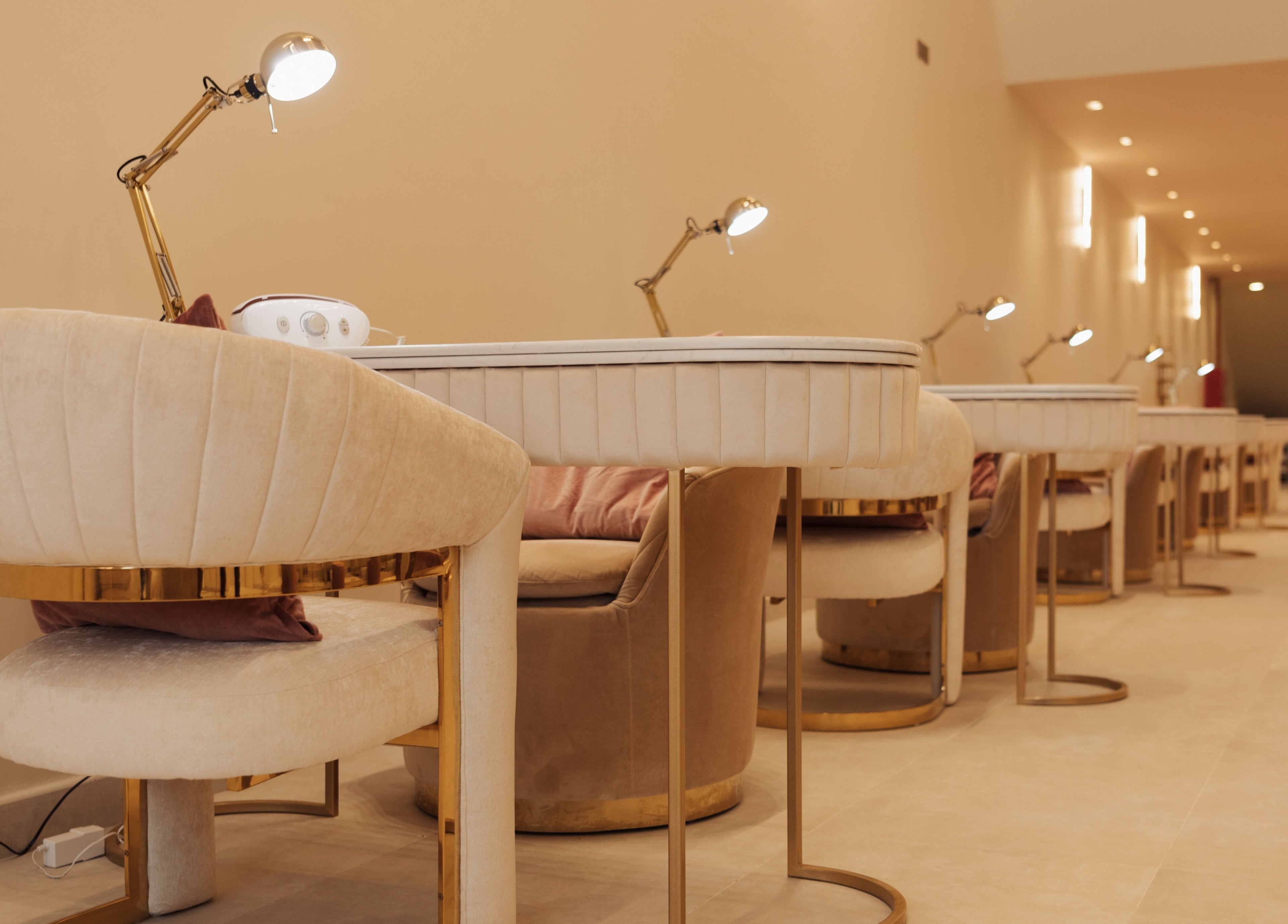 Luxurious nail salon workspace at Infinity Nails, Riyadh, features plush chairs and modern lighting.