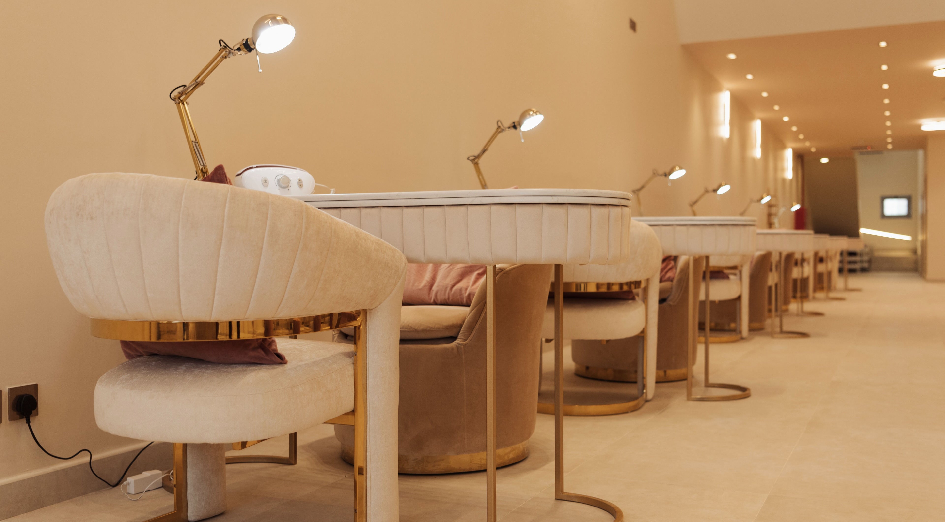 Luxurious nail salon workspace at Infinity Nails, Riyadh, features plush chairs and modern lighting.