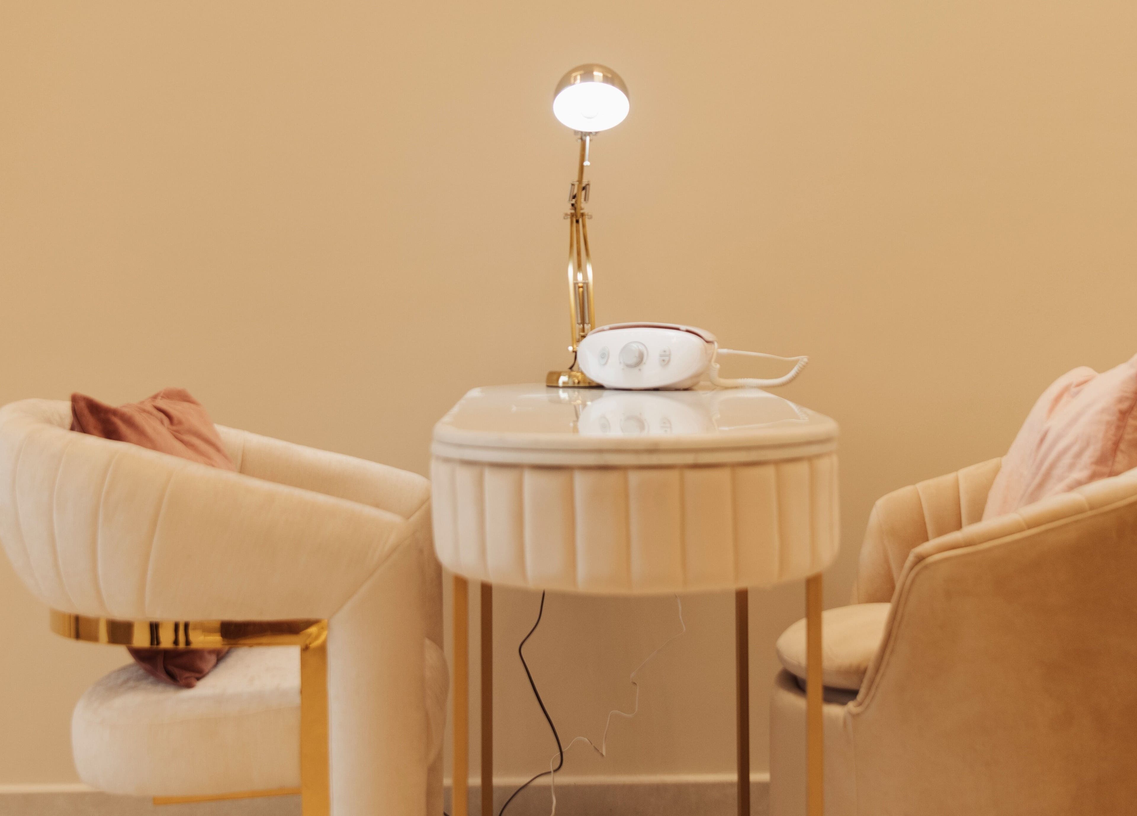 Elegant nail service setup at Infinity Nails, Riyadh, with plush chairs and table.
