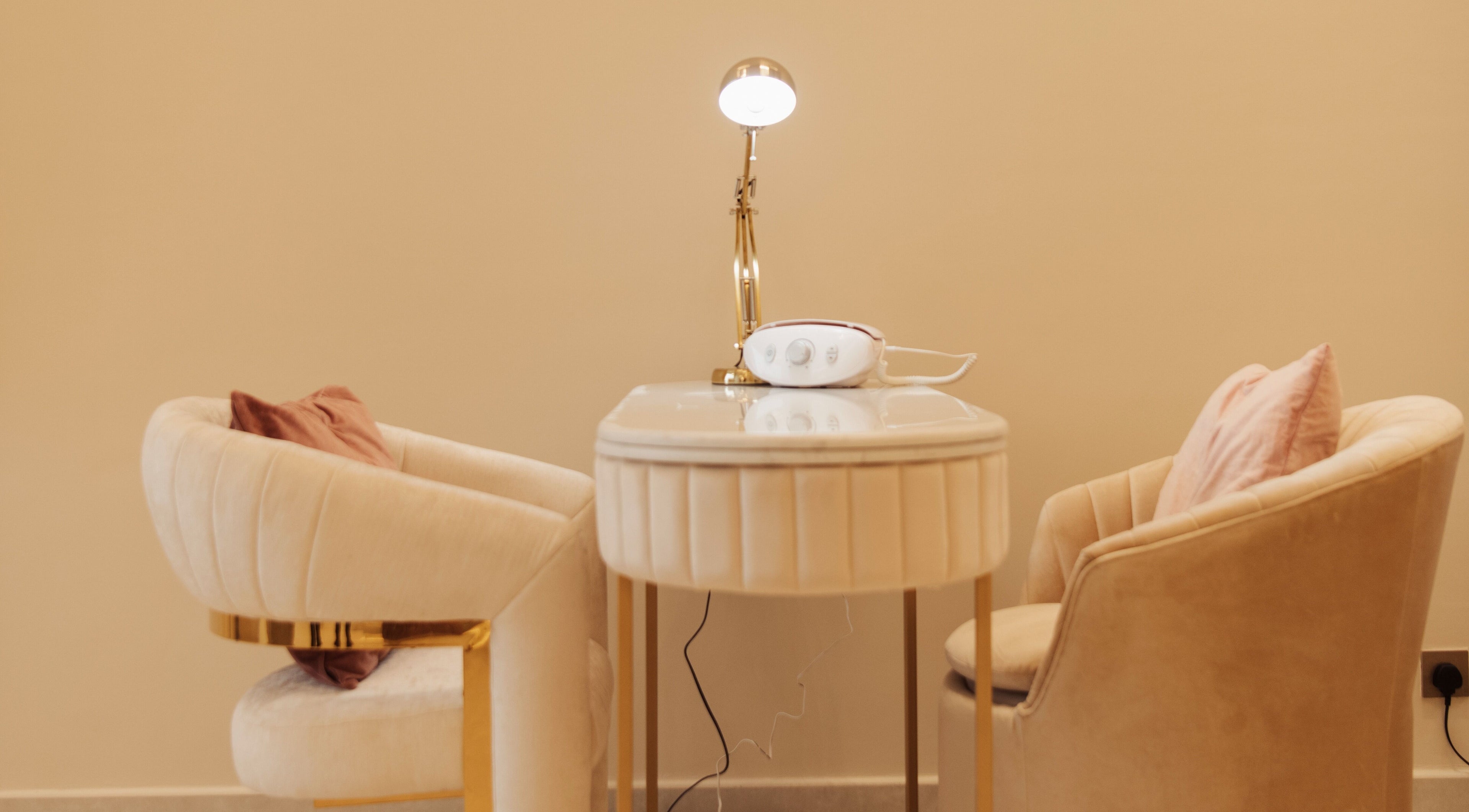 Elegant nail service setup at Infinity Nails, Riyadh, with plush chairs and table.