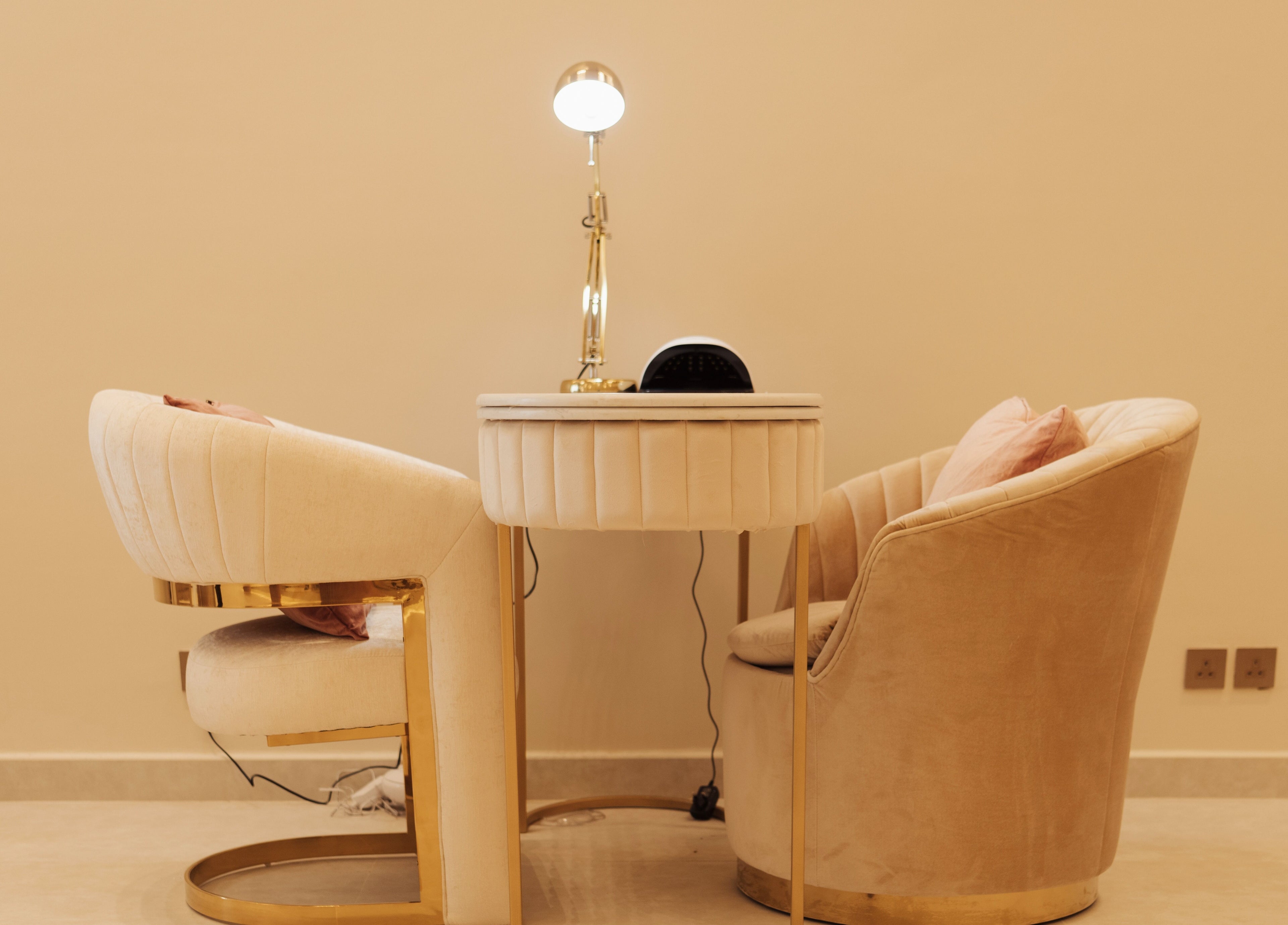 Luxury nail salon setup at Infinity Nails, Riyadh, with plush chairs and a sleek table enhancing comfort.