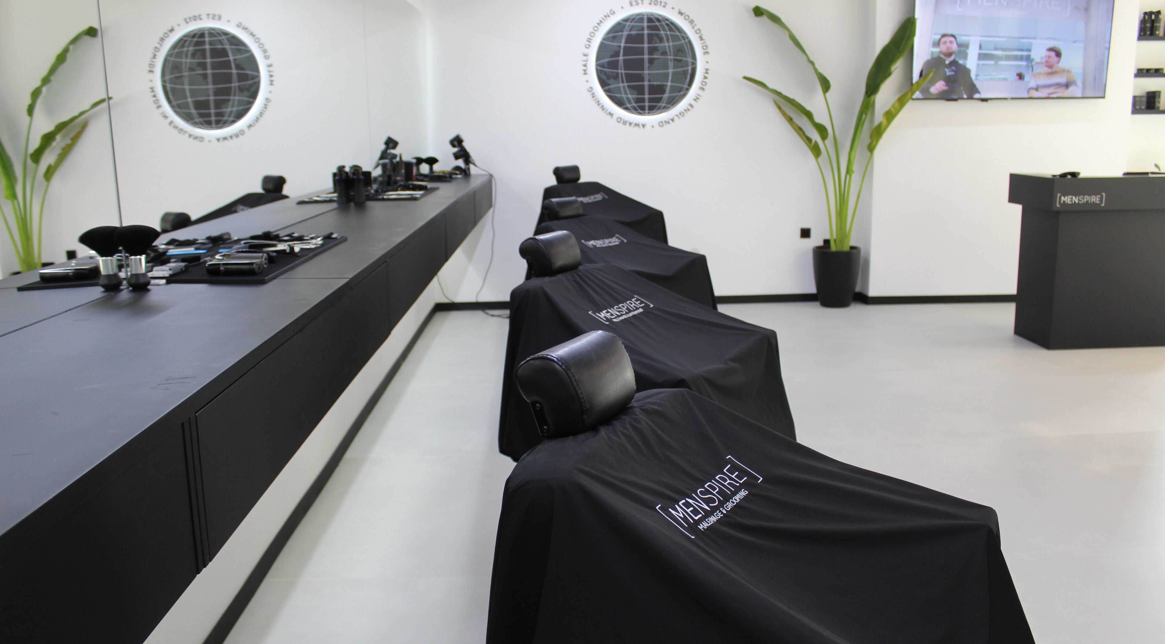 Modern barbershop interior at Menspire Dubai, Dubai, AE featuring sleek chairs and high-end grooming tools.