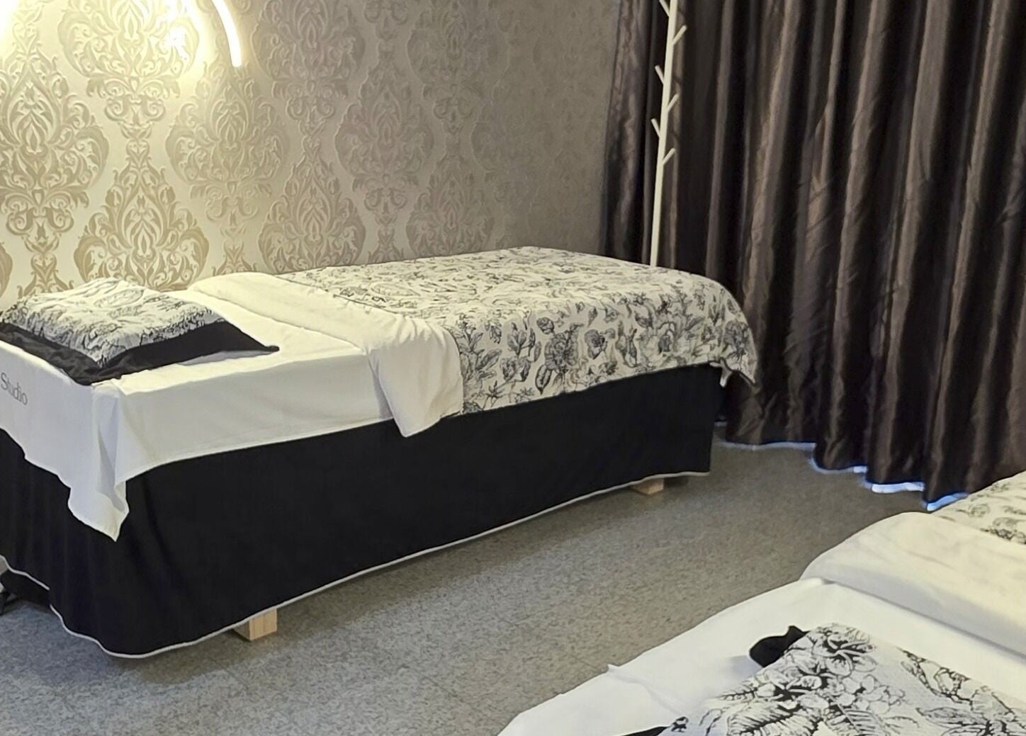 Luxurious massage room at Joie's Studio, Singapore, SG, featuring elegant decor and a cozy treatment bed.