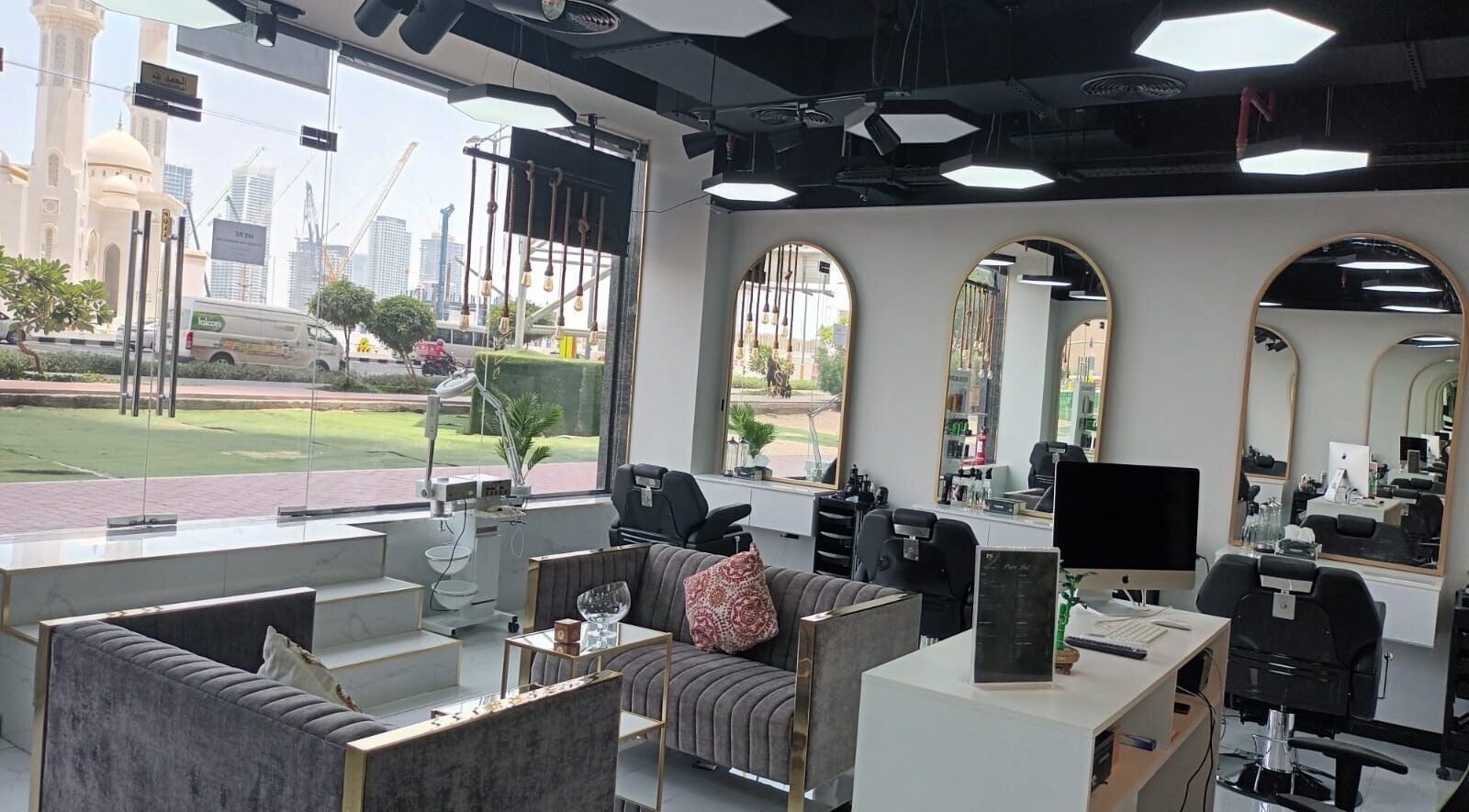 Modern interior of Majestic Fade Gents Salon in Dubai, Dubai, AE featuring plush seating and sleek mirrors.