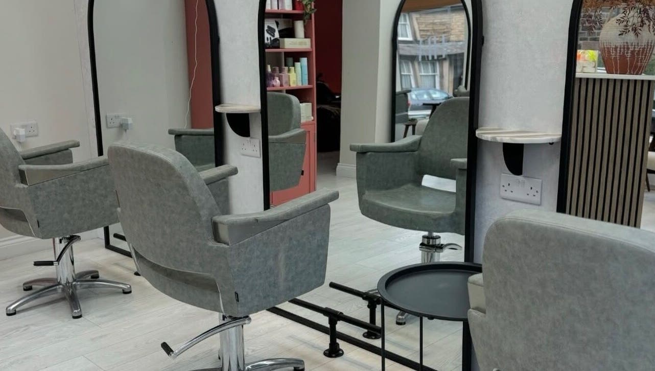 Modern salon interior at Hair by Izzy, Harrogate, England, GB, highlighting chic styling chairs and mirrors.