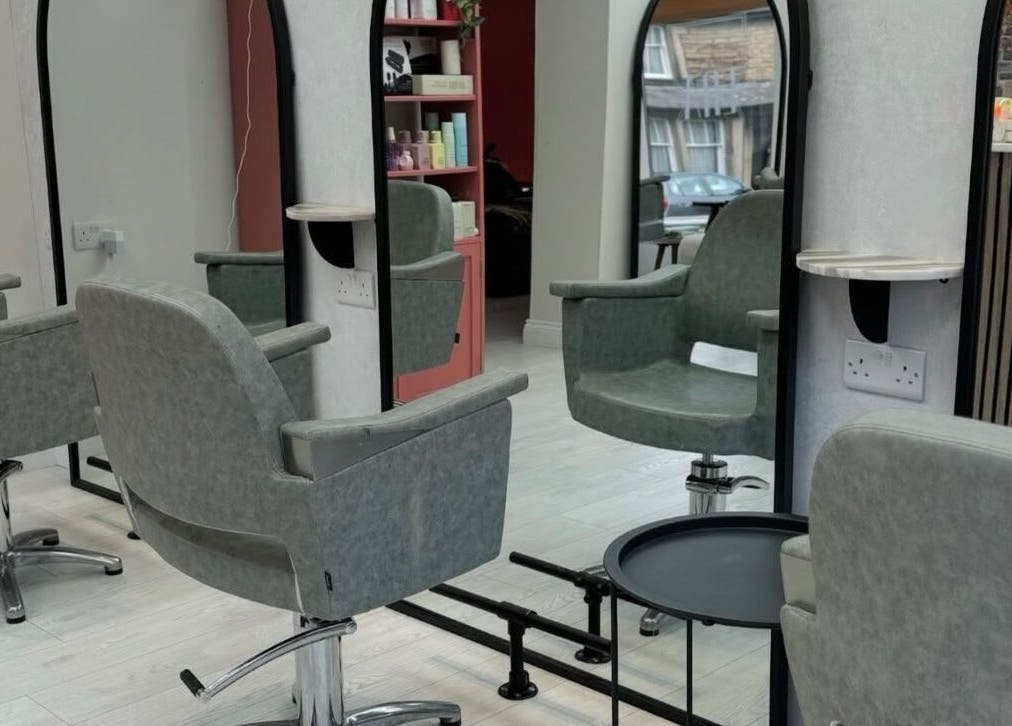 Modern salon interior at Hair by Izzy, Harrogate, England, GB, highlighting chic styling chairs and mirrors.
