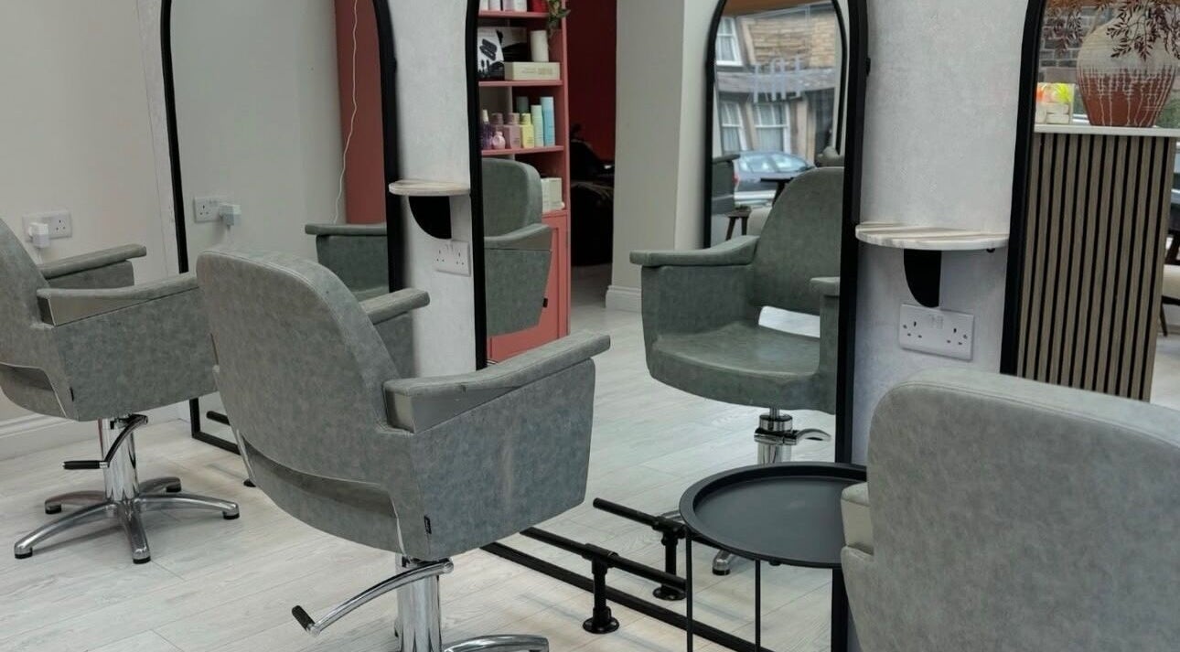 Modern salon interior at Hair by Izzy, Harrogate, England, GB, highlighting chic styling chairs and mirrors.