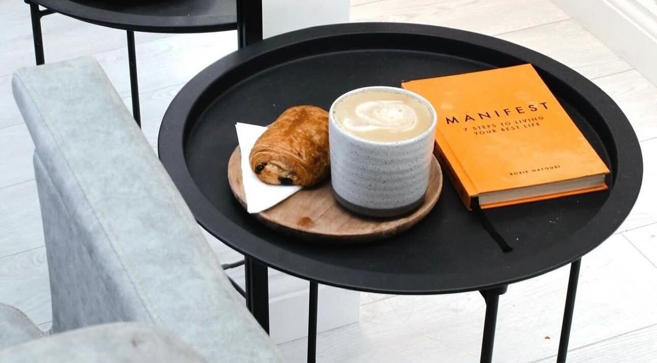Relaxing coffee setup at Hair by Izzy, Harrogate, England, GB with a book and pastry.