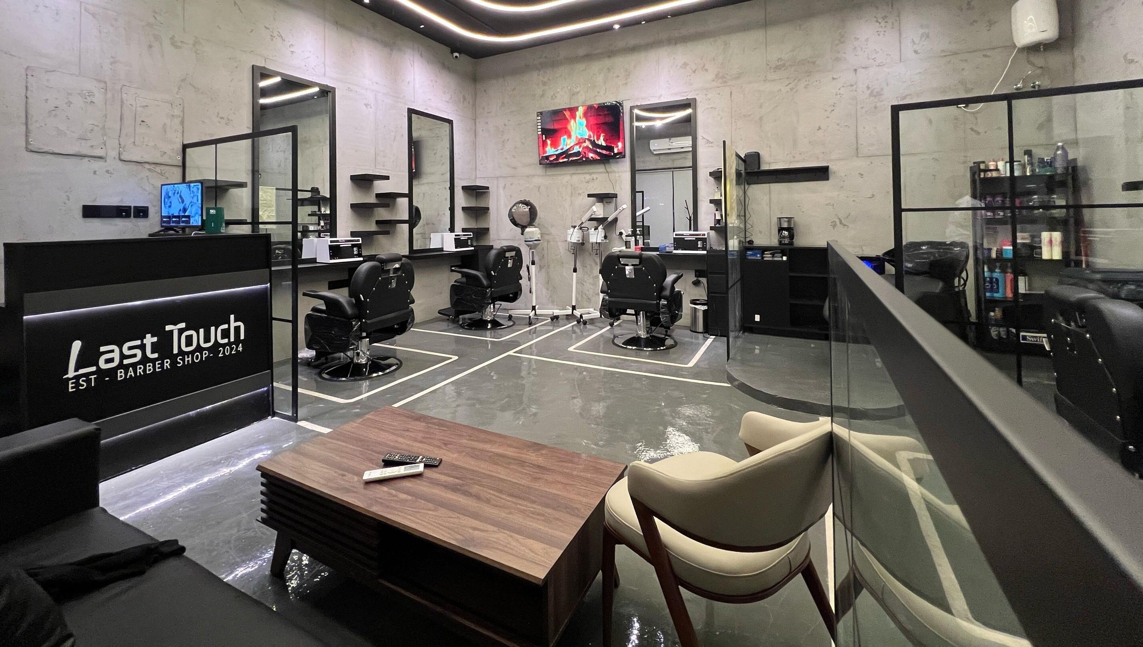 تصميم داخلي أنيق لصالون Last Touch في الرياض، الرياض، SA مع كراسي وأدوات حلاقة حديثة.