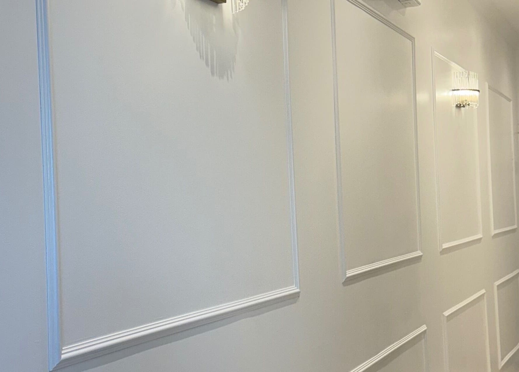 Bright hallway at The Smile Palette, London, England, GB with elegant wall panels and lighting.