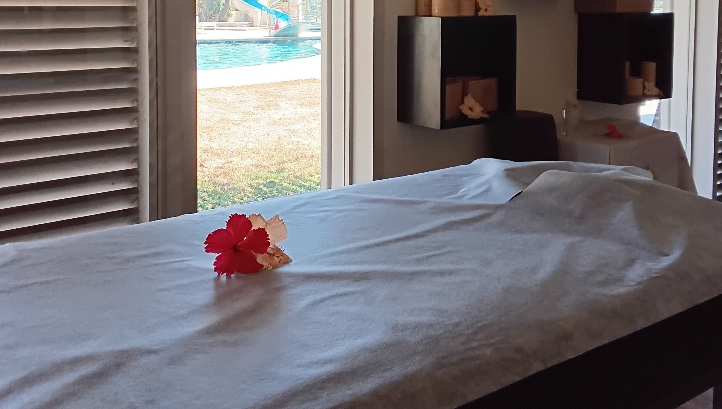 Relaxing massage table with flower at Nama Fiji, Nadi, Western Division, FJ, overlooking tranquil pool view.