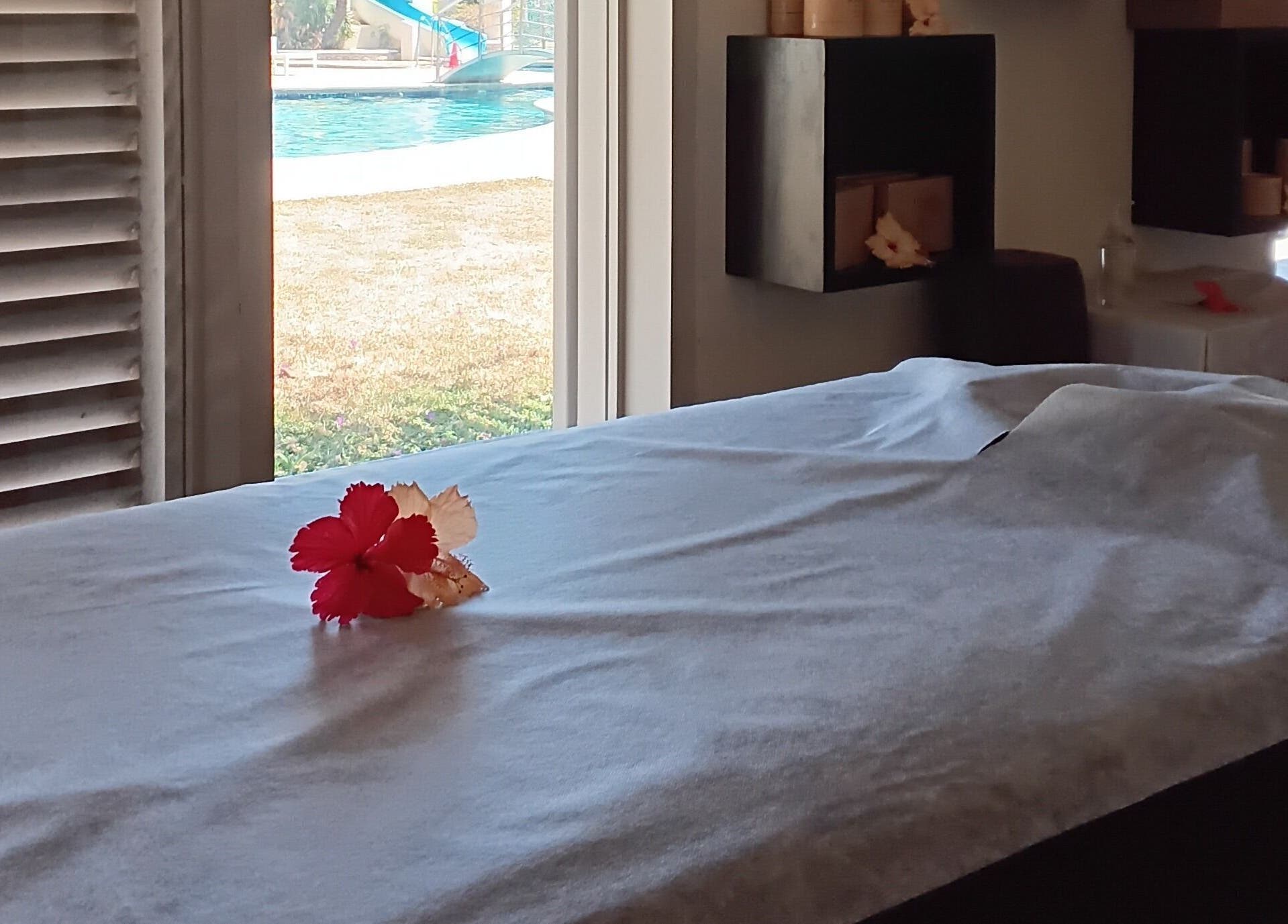 Relaxing massage table with flower at Nama Fiji, Nadi, Western Division, FJ, overlooking tranquil pool view.