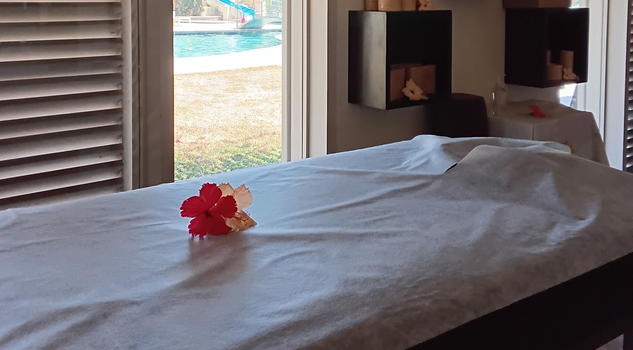 Relaxing massage table with flower at Nama Fiji, Nadi, Western Division, FJ, overlooking tranquil pool view.
