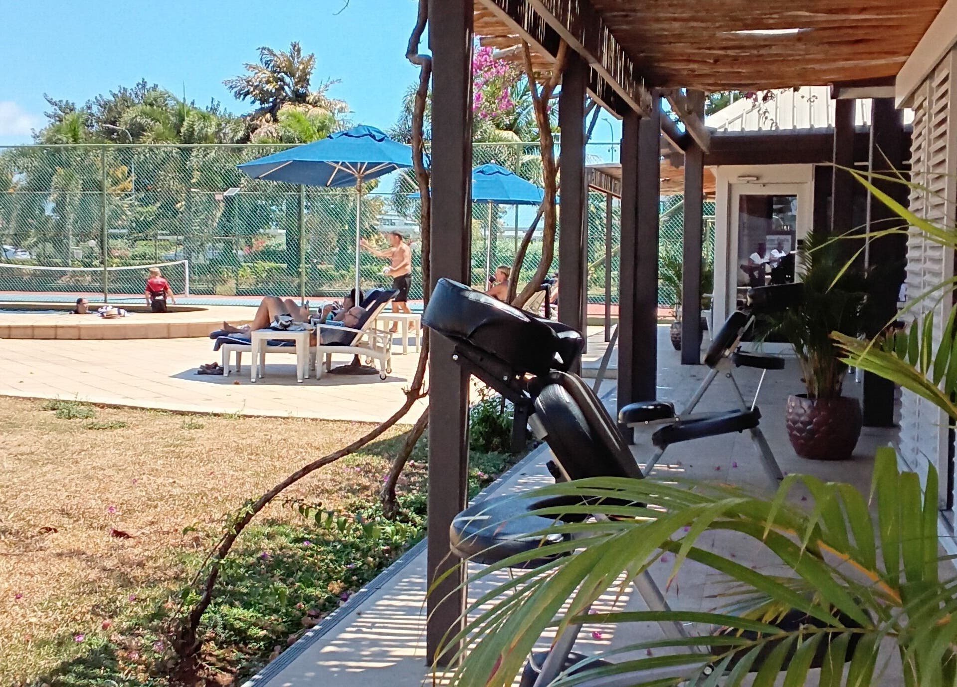 Relaxing poolside view at Nama Fiji, Nadi, Western Division, FJ, surrounded by palm trees and lounge chairs.