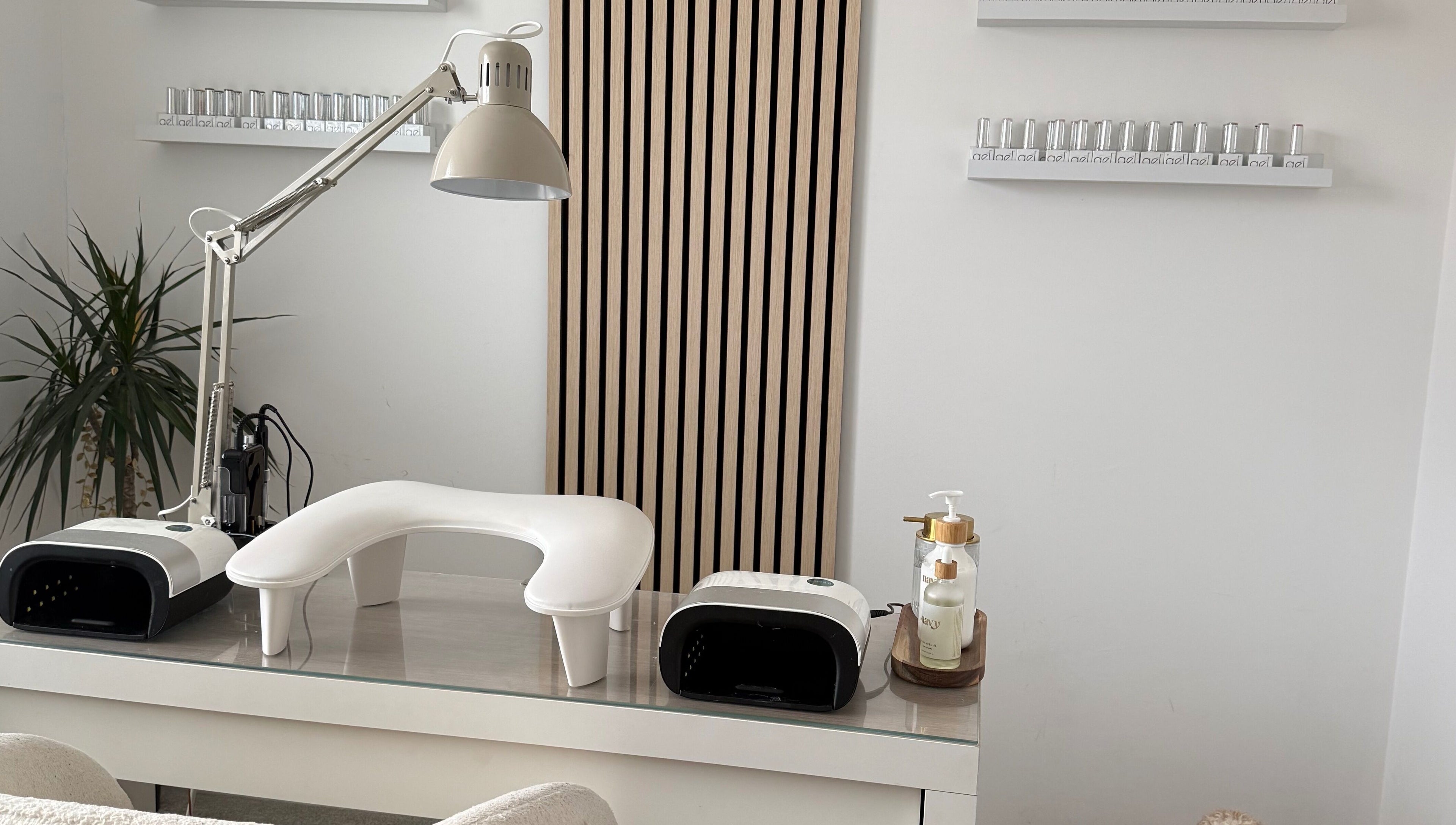 Modern nail station at Nails By Lara, Nottingham, England, GB featuring nail lamp and polish display.