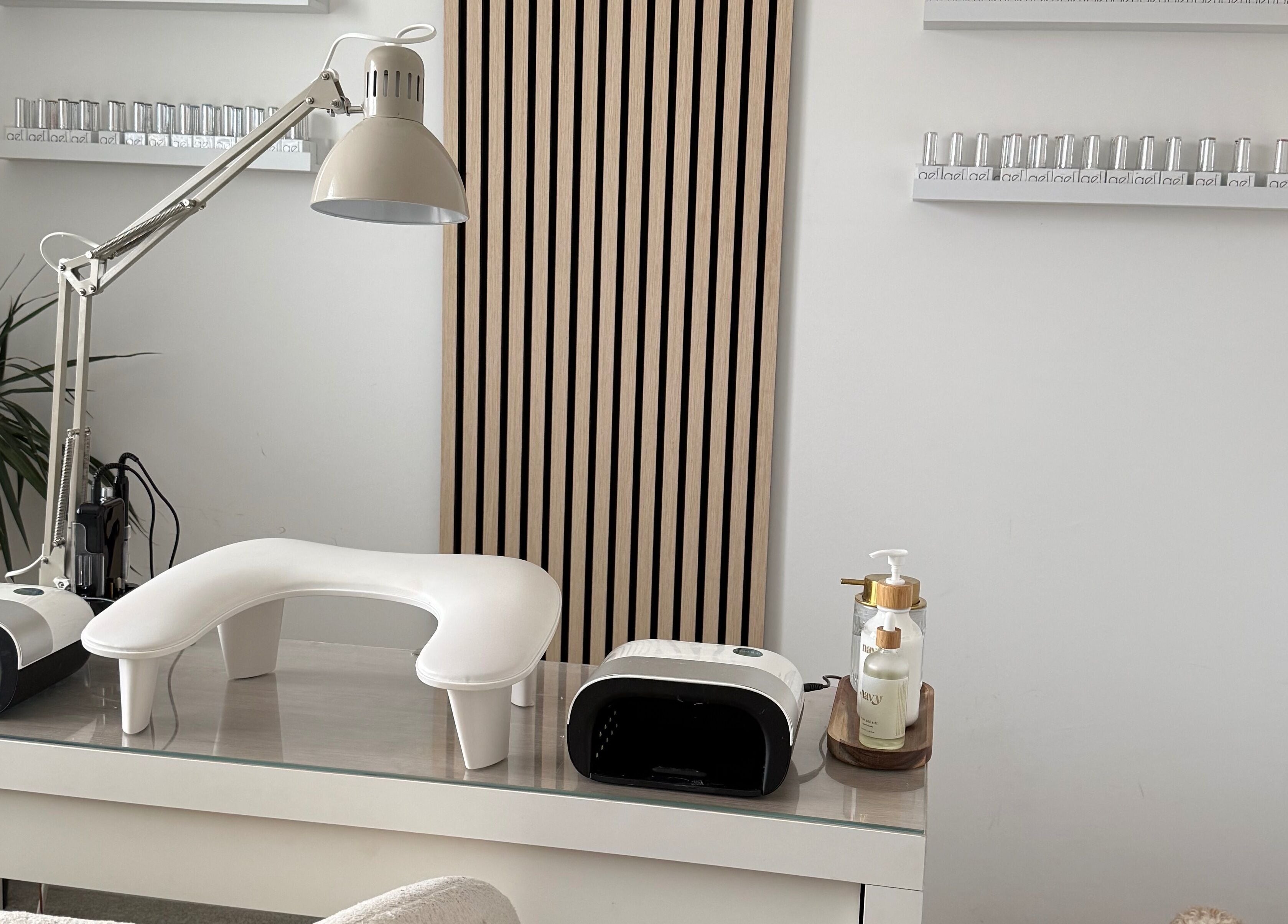 Modern nail station at Nails By Lara, Nottingham, England, GB featuring nail lamp and polish display.