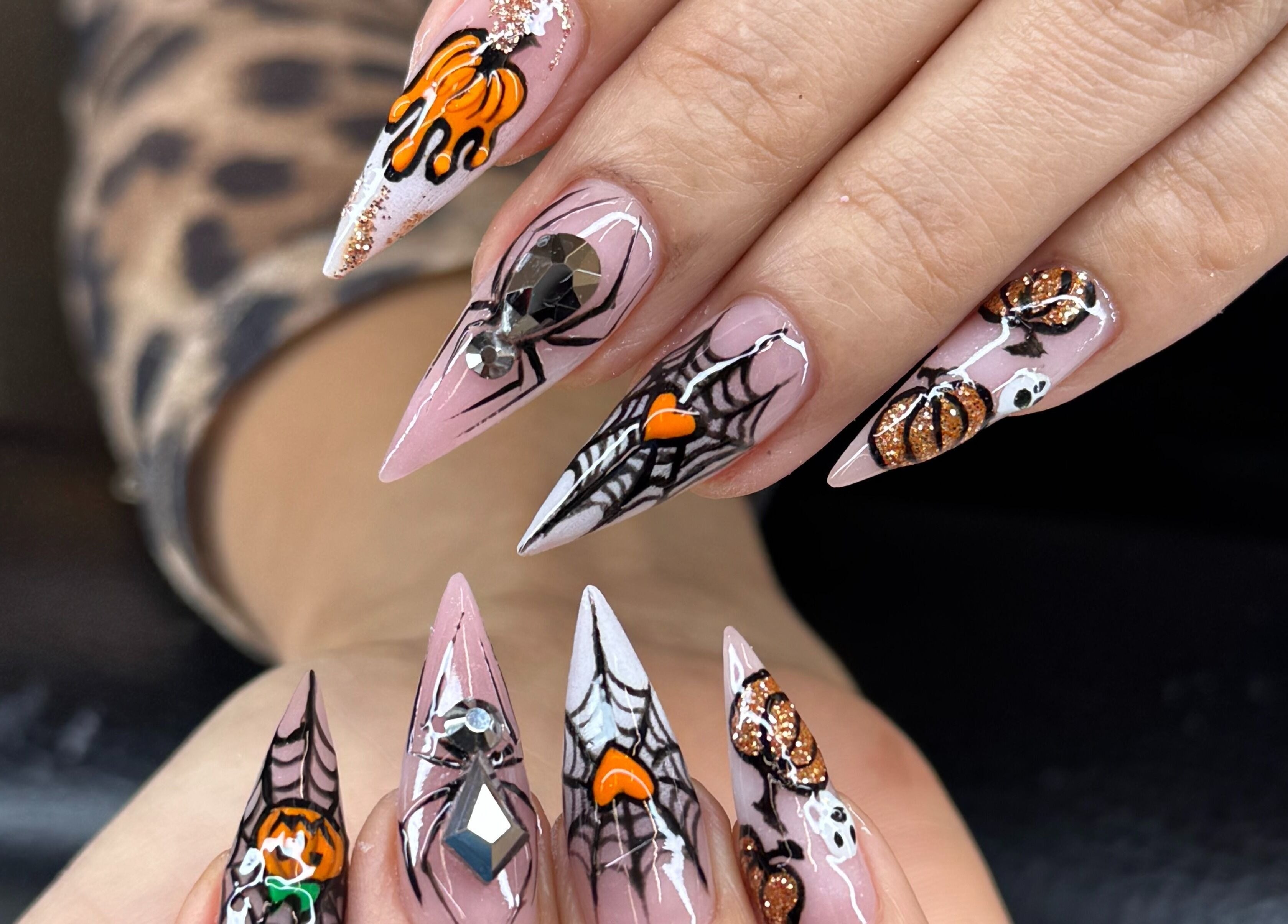 Intricate Halloween nail art with pumpkins and webs at Icon Nails & Beauty, Zürich, Zürich, CH.