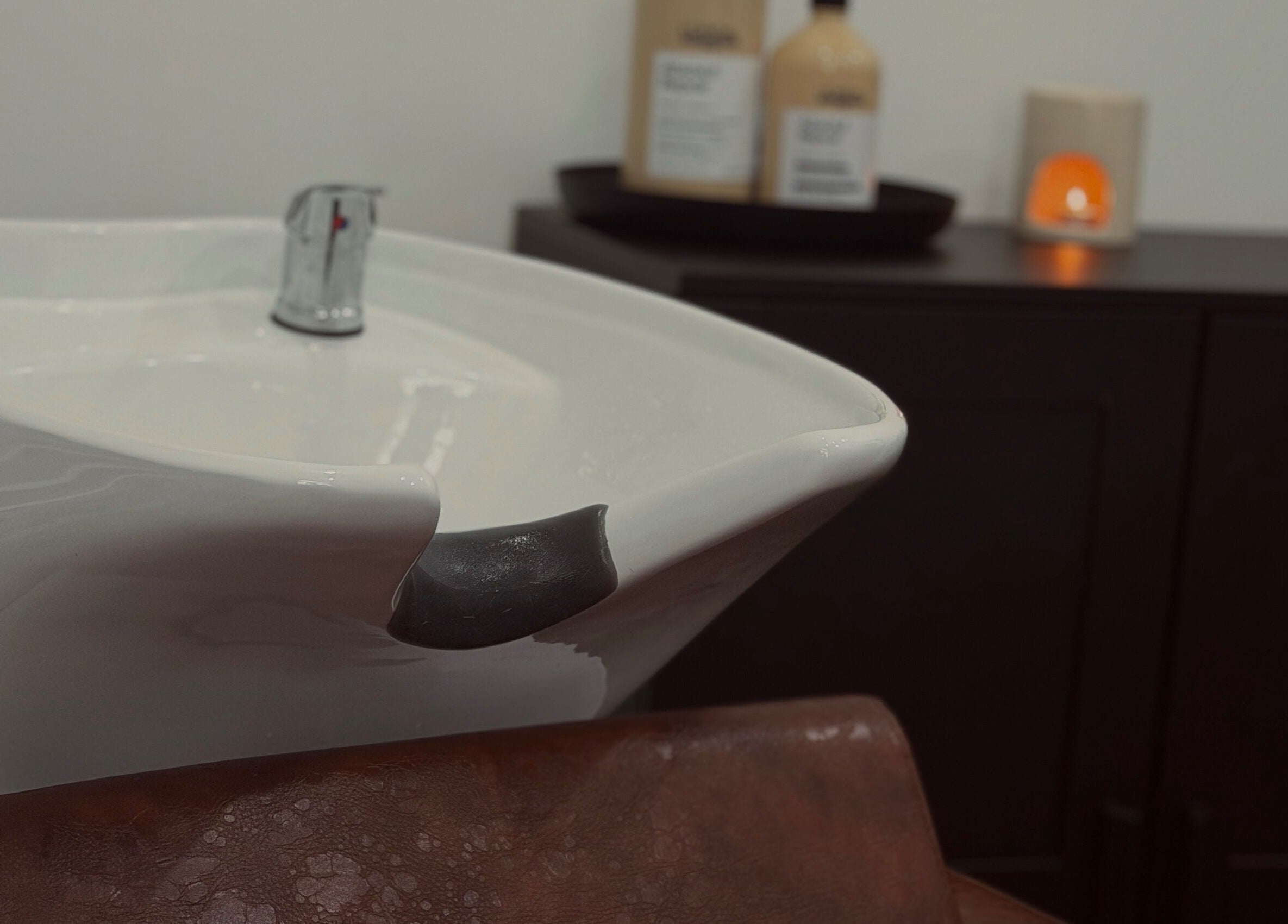 Hair washing station at MS Hairdressing in Colchester, England, GB with a modern sink and products.