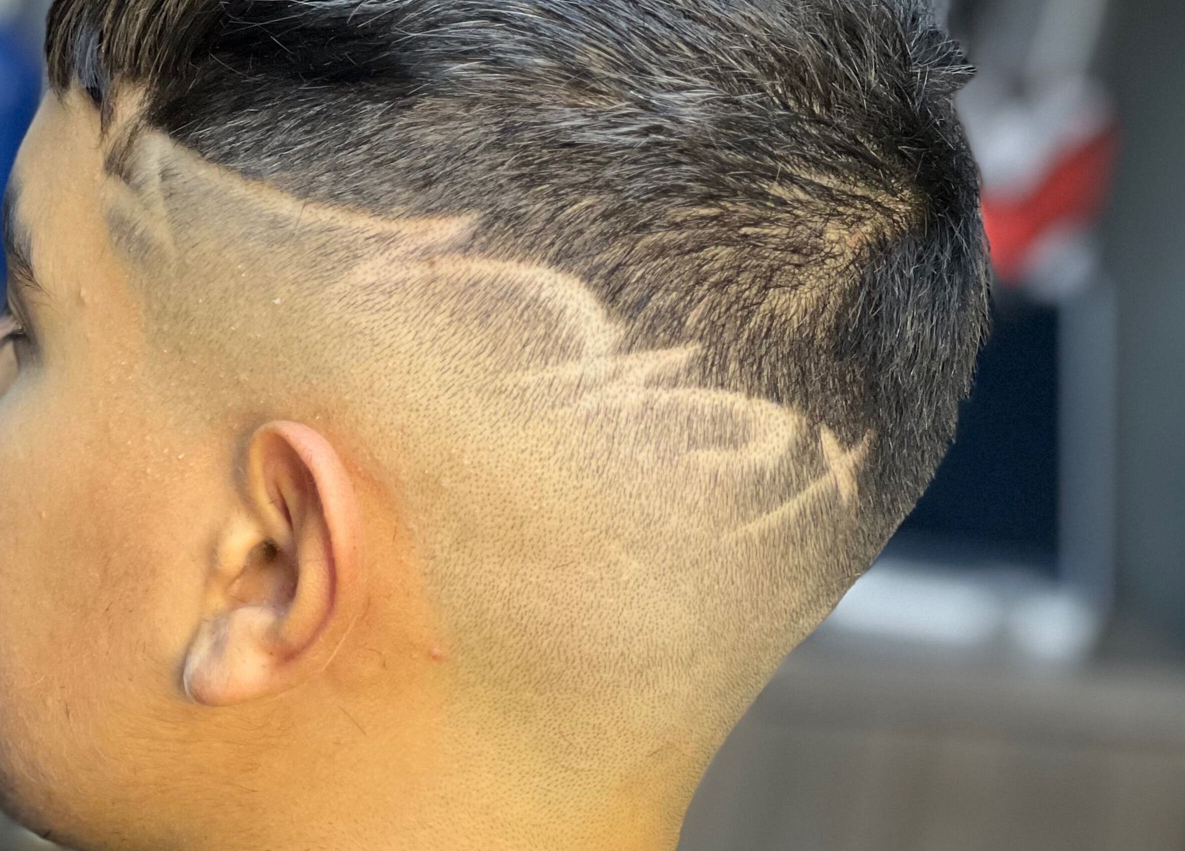 Close-up of a trendy fade haircut with designs at The Town Barber, Żabbar, MT.