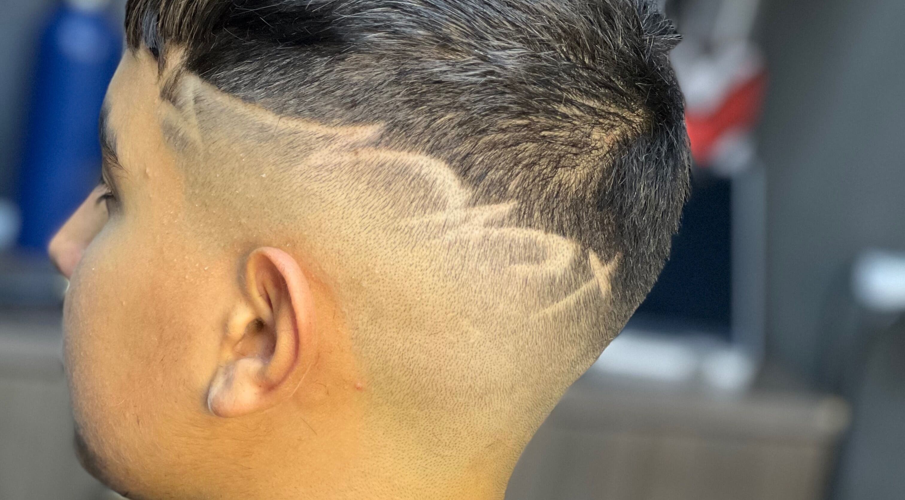 Close-up of a trendy fade haircut with designs at The Town Barber, Żabbar, MT.